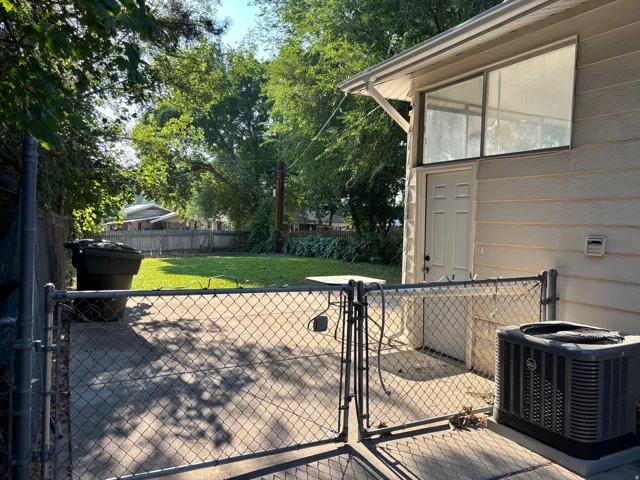 Concrete patio with chain-link fencing and gate