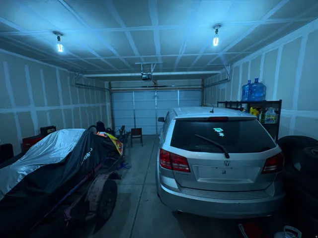 Attached two-car garage with a single overhead door and exposed ceiling joists
