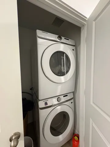 Stacked washer and dryer unit within a dedicated utility closet