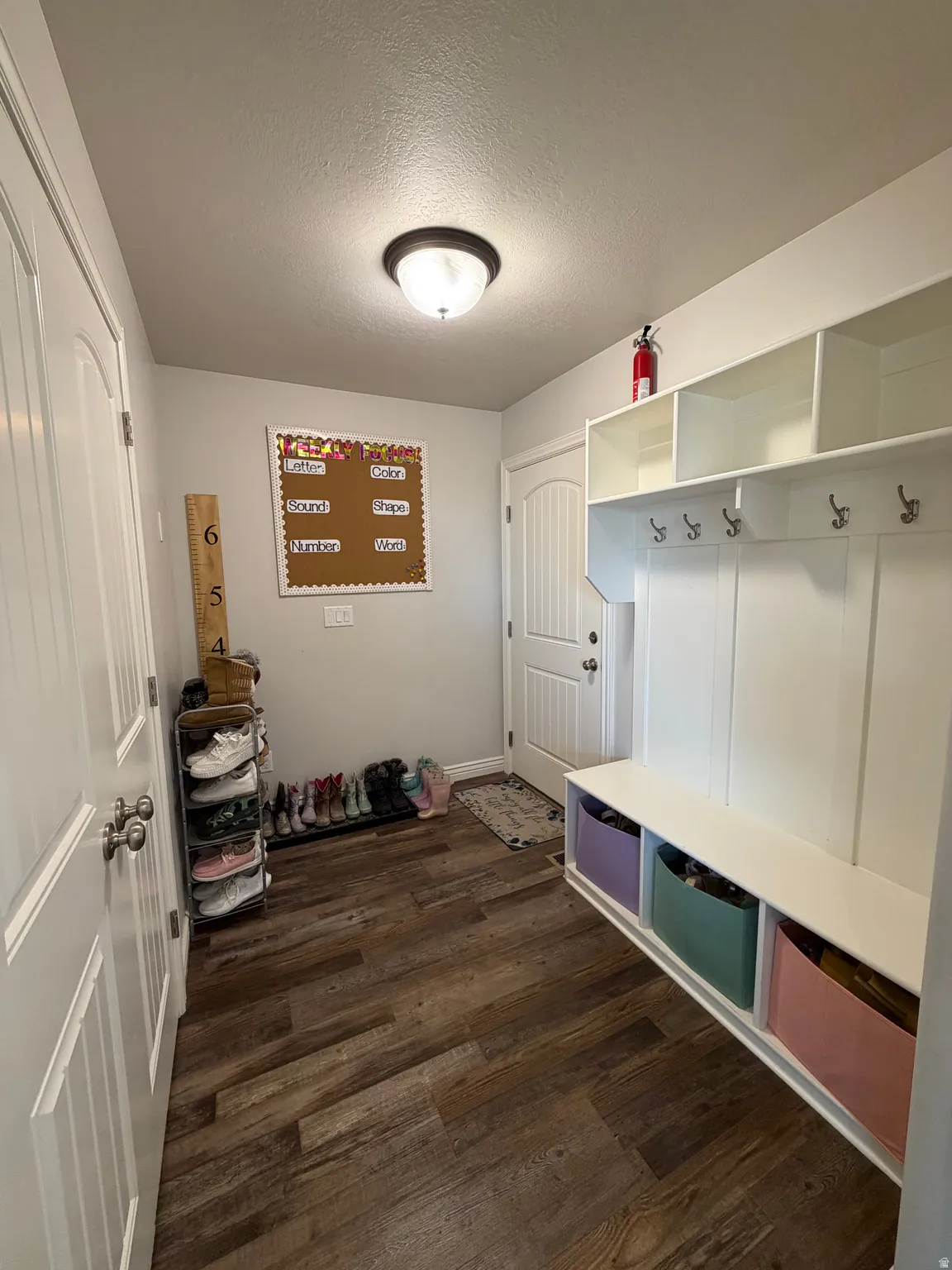 Drop zone with built-in storage bench, integrated coat hooks, and upper storage cubbies. Large Double Door Pantry