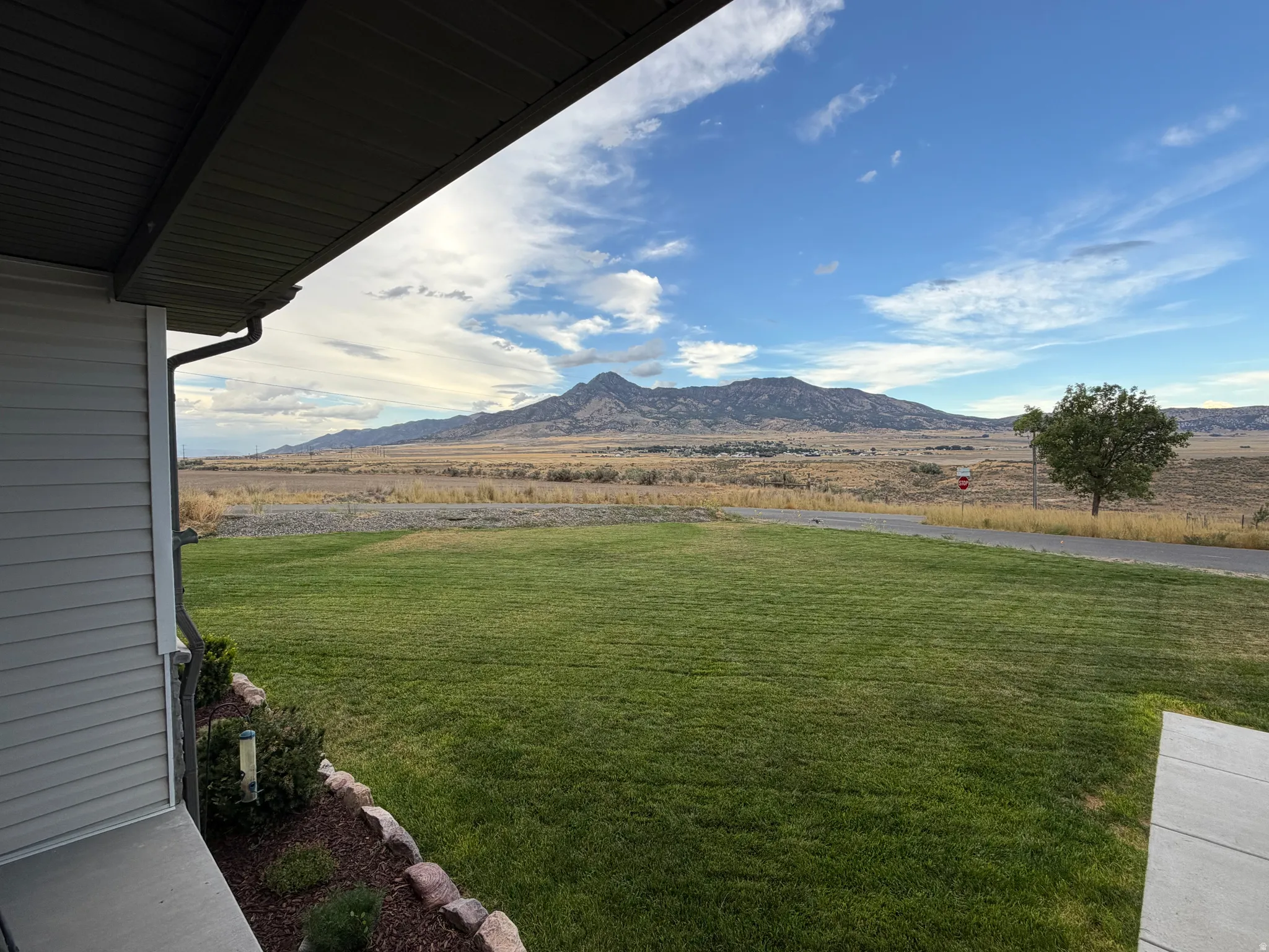 Expansive green lawn with mountain views from front porch