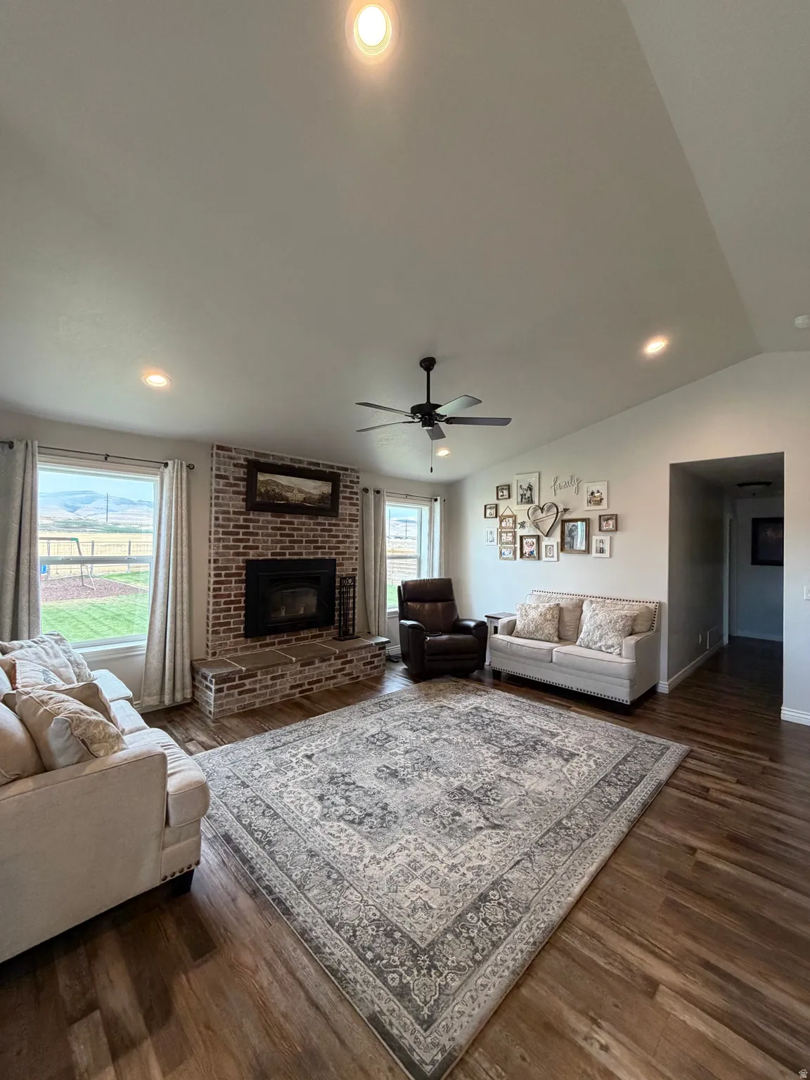 Main Floor Great Room with Built-in Wood Burning Stove, brick-surround fireplace and hearth flanked by windows for beautiful views
