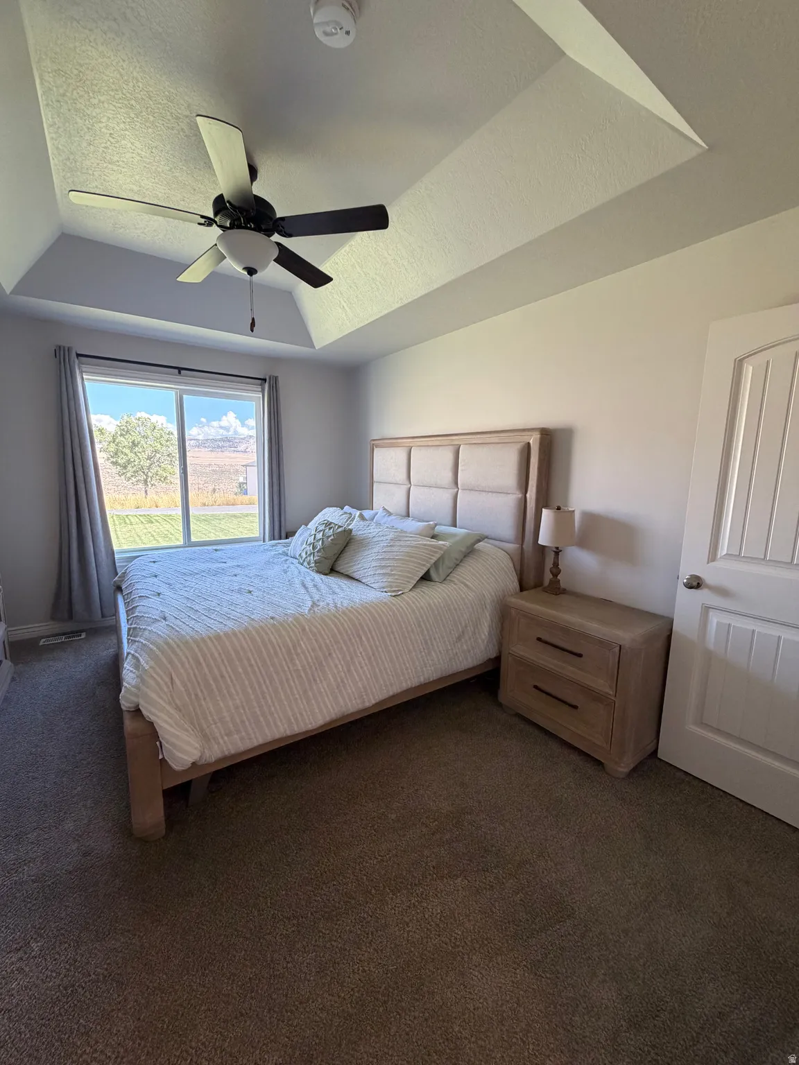Primary Suite: Tray ceiling with a ceiling fan and a large window with amazing views!