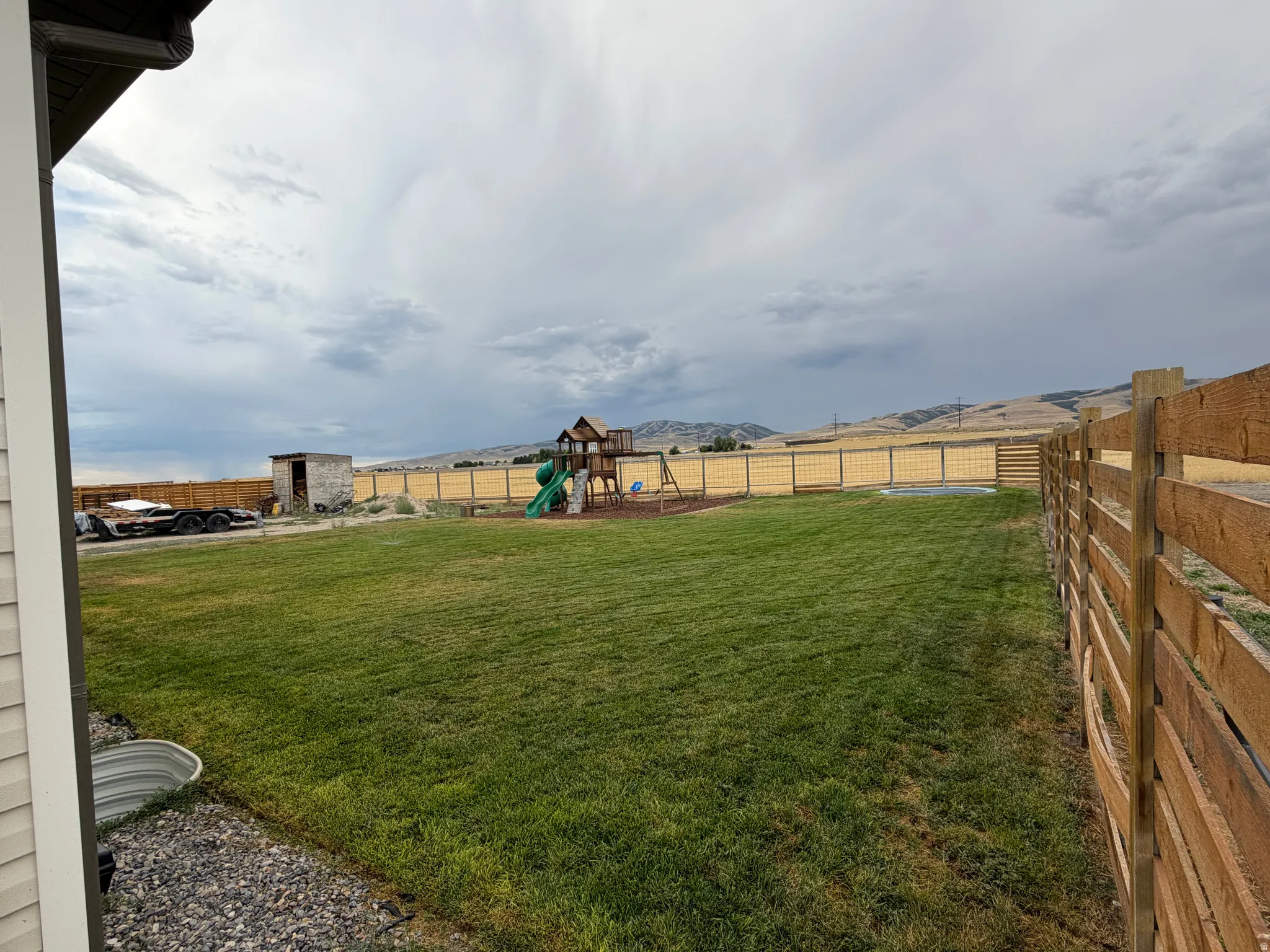 Expansive grassy backyard featuring a wood & Wire fence and amazing views