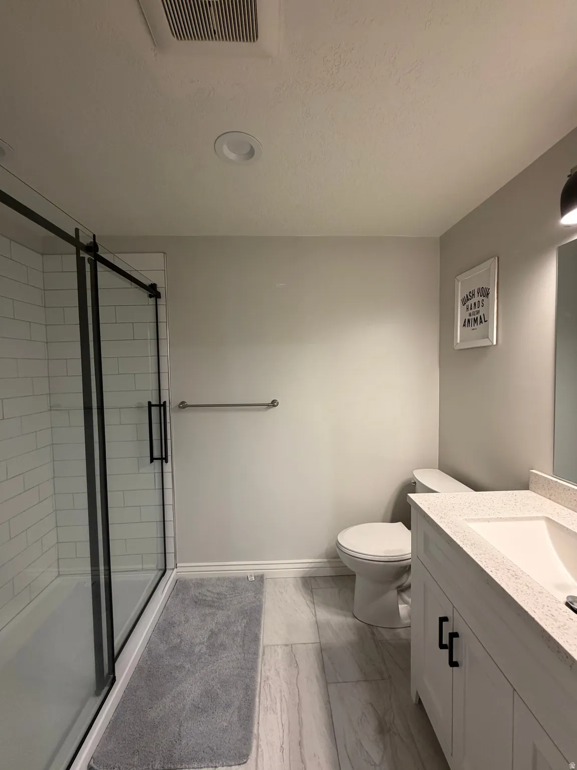Basement Bath: featuring large walk-in Shower with subway tile and black-framed glass sliding doors.