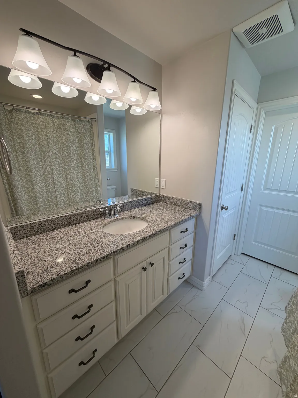 Primary Suite Bathroom Granite countertop and linen closet.