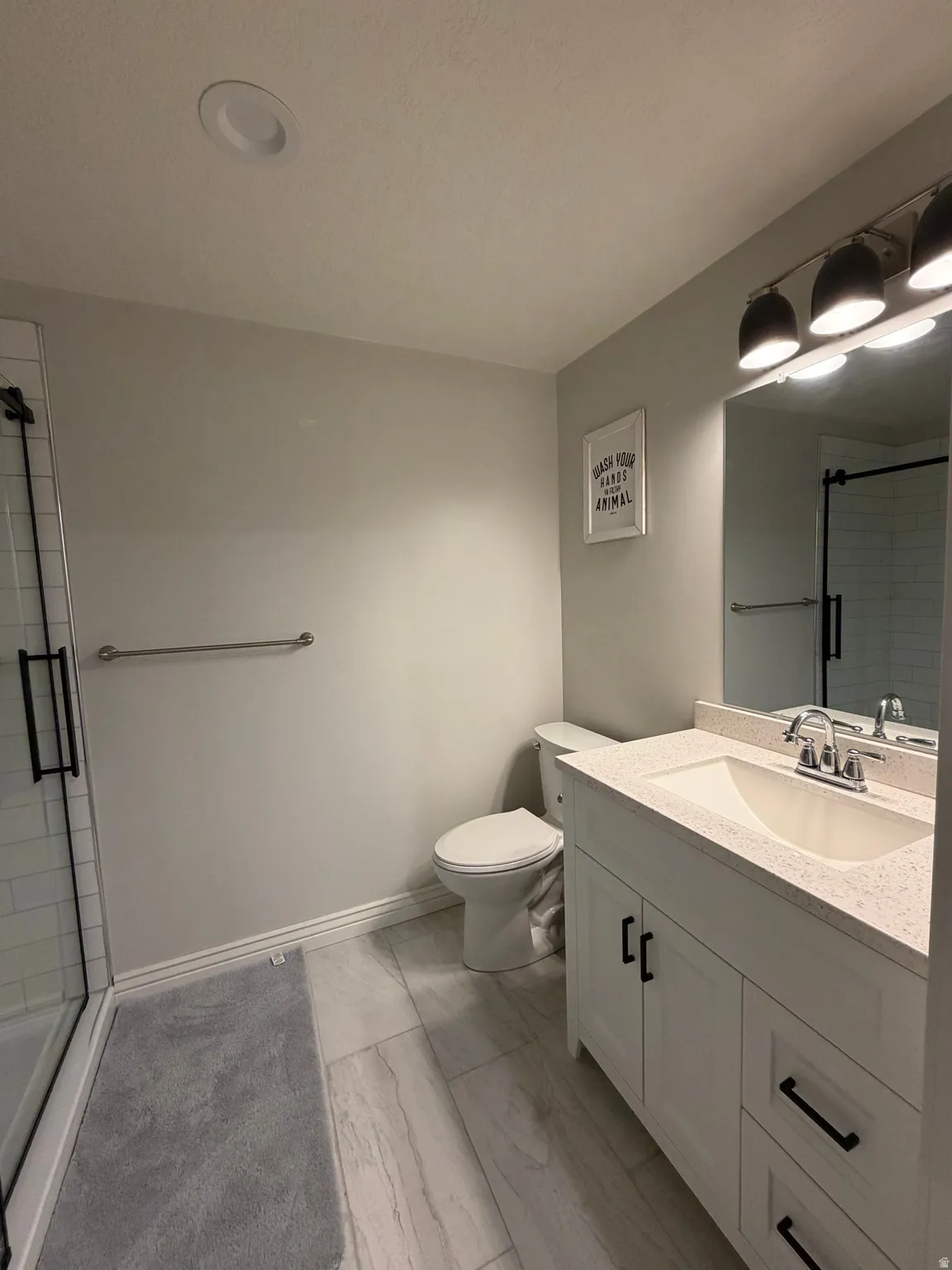 Basement Bath: Vanity with integrated sink and chrome fixtures, and wood plank style tile.