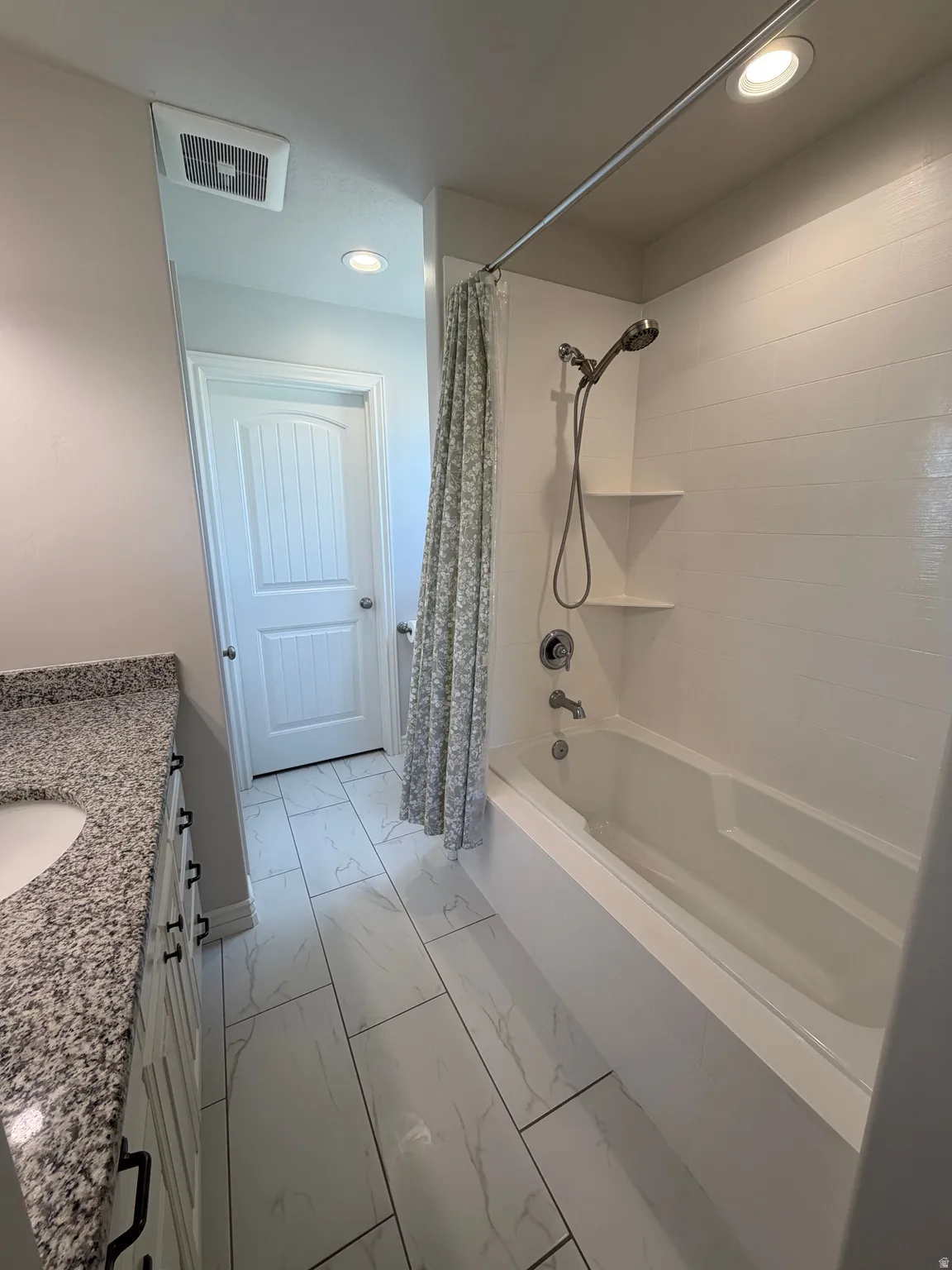 Primary Suite Bathroom with oversized Bathtub shower Combo, granite Countertops and tile floor.