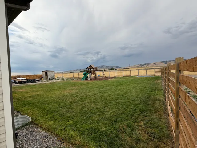 Expansive grassy backyard featuring a wood & Wire fence and amazing views