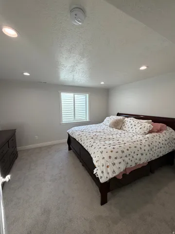 Bedroom 3: Basement large bedroom with plush carpet flooring and shown with king size bed