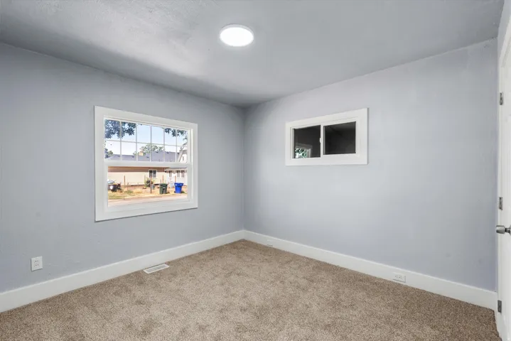 Neutral wall tones, recessed ceiling lighting, and carpet flooring