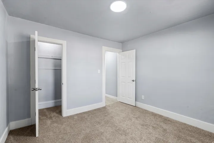 Carpeted flooring, light gray wall finish, white trim, recessed lighting, and white paneled doors