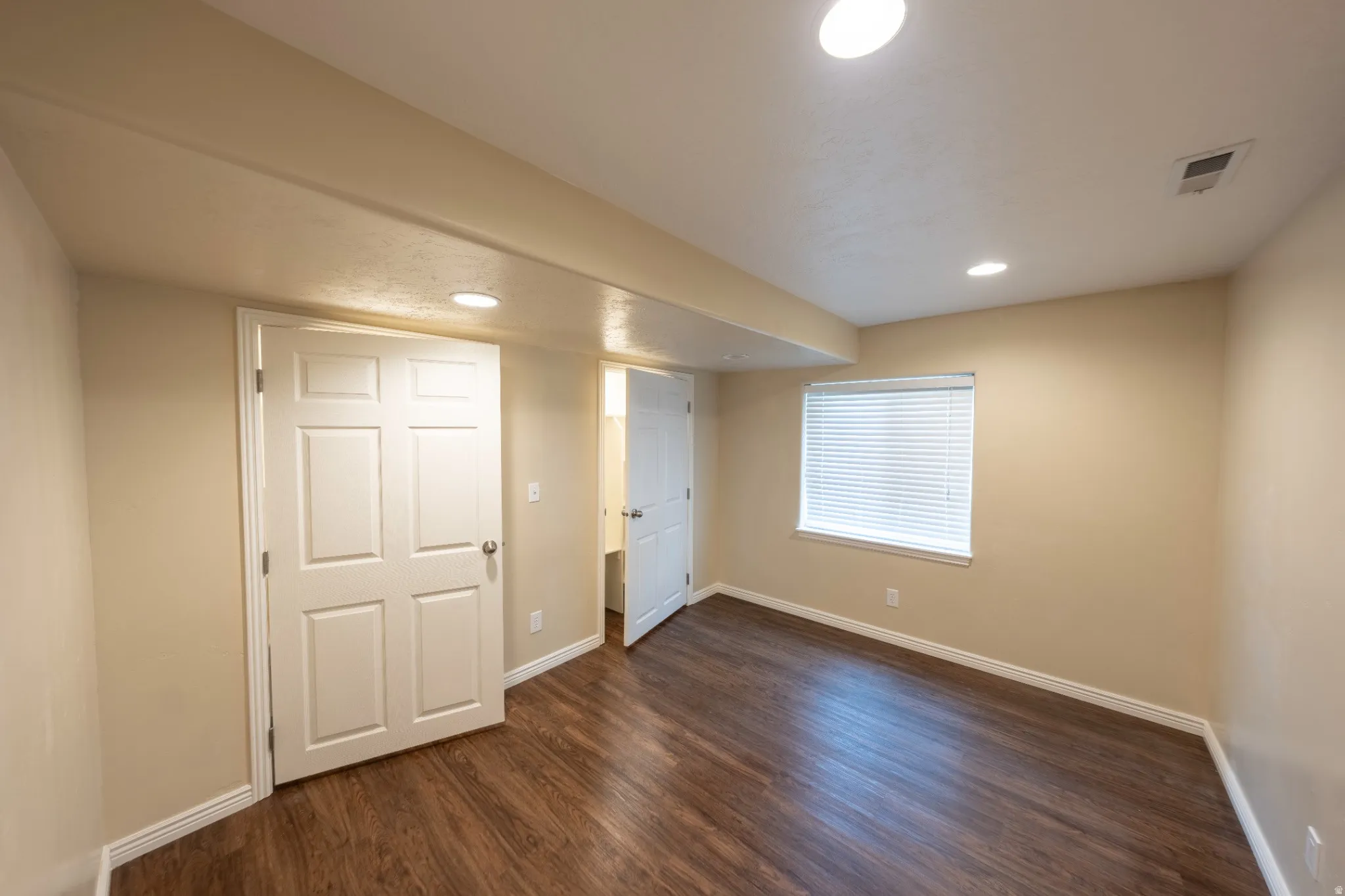 Recessed lighting illuminates wood-finish flooring
