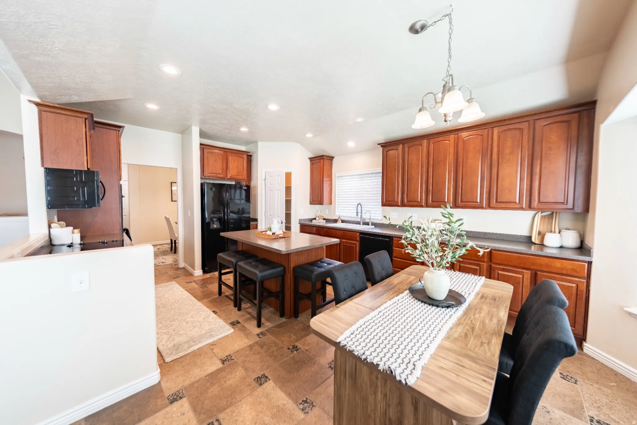 Kitchen featuring wood cabinetry, an island with seating, a built-in oven, and recessed lighting