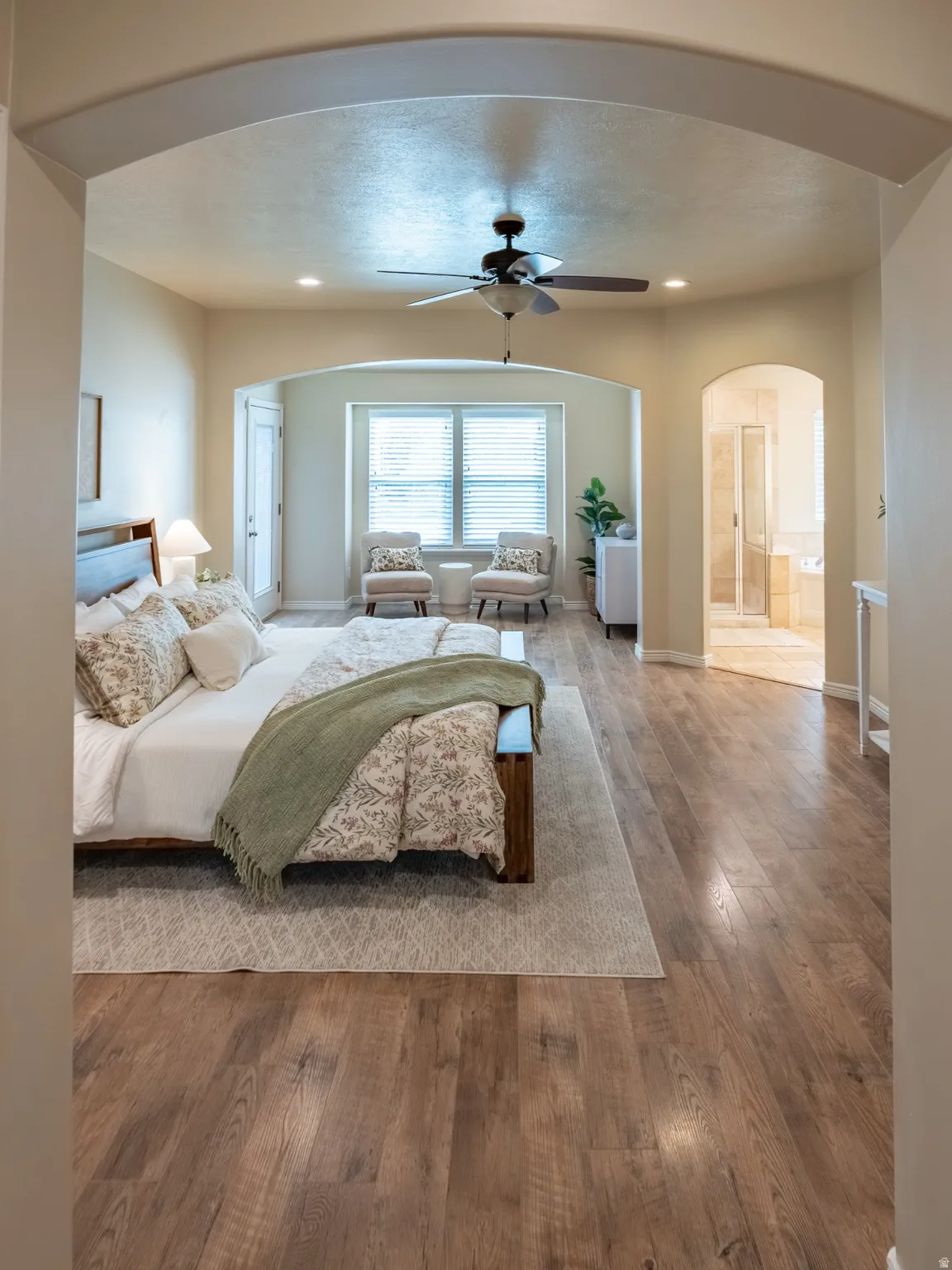 Expansive room featuring wood-finish flooring, recessed lighting, and a ceiling fan