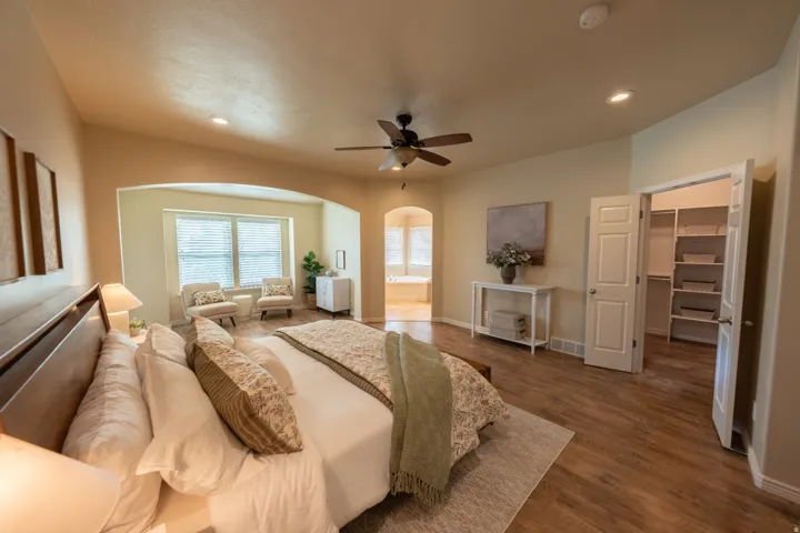 Wood-finish flooring, recessed lighting, ceiling fan, and arched doorways