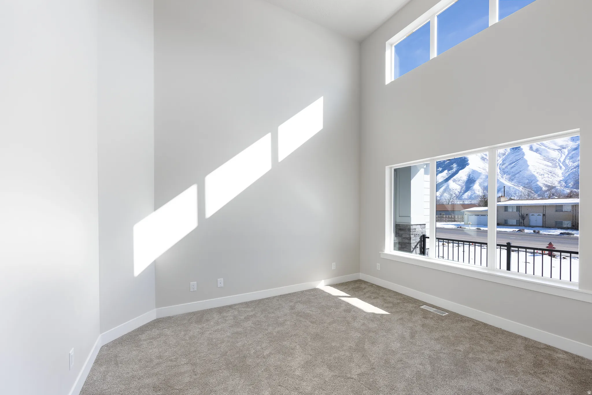 Two-story ceiling, large windows, transom windows, and wall-to-wall carpeting
