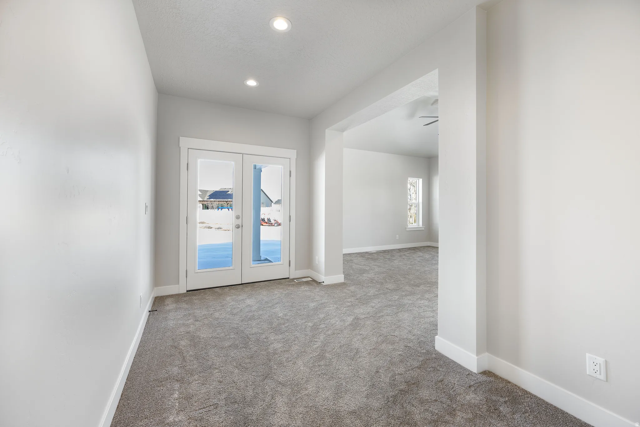 Recessed lighting, French doors with clear glass, light gray carpeting, neutral wall paint, and white trim