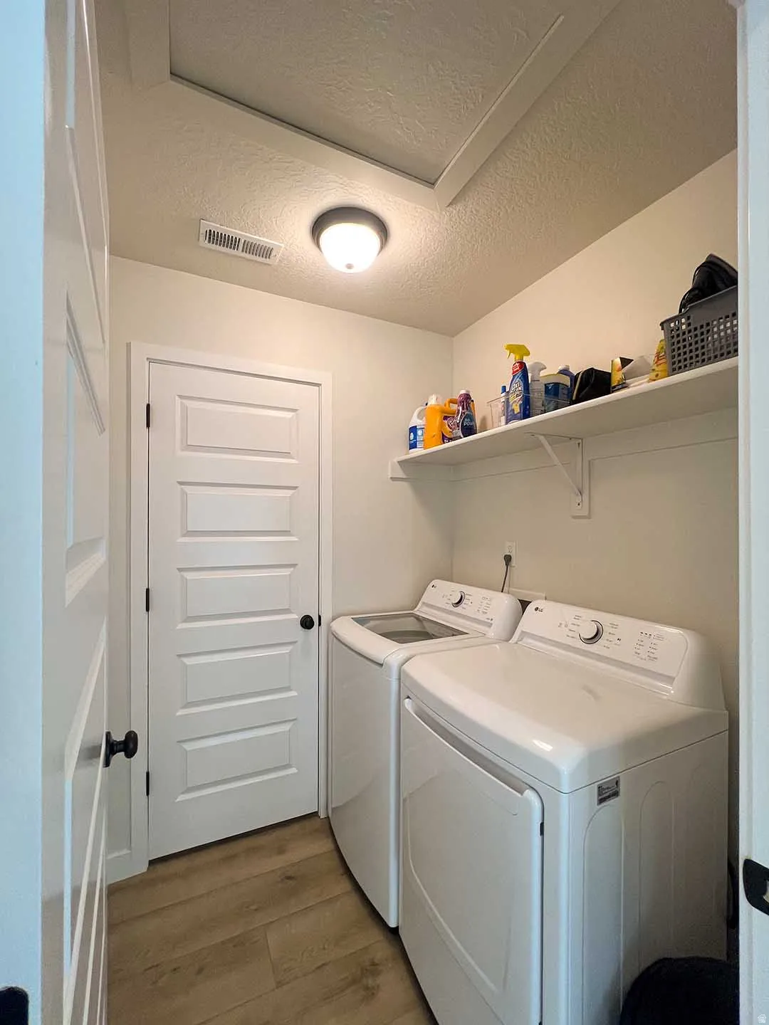Built-in shelving, wood-finish flooring, recessed lighting, and white paneled doors