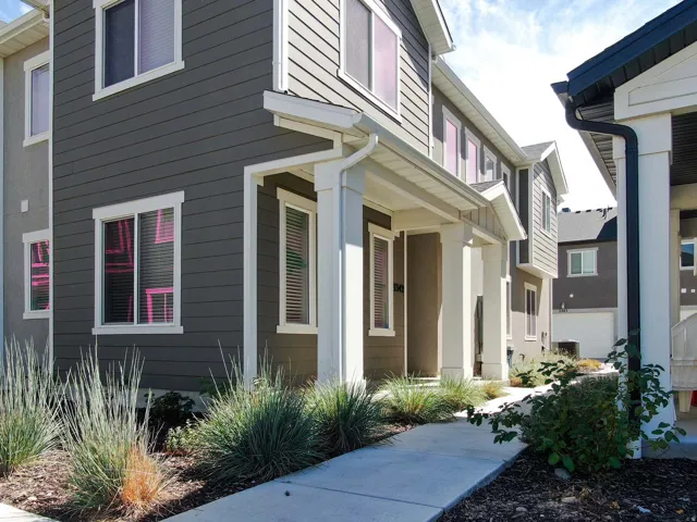 Multi-story residential facade with dark gray horizontal siding and white trim