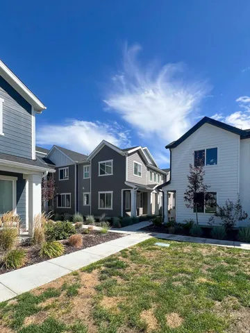 Contemporary townhome exteriors featuring varied siding materials and landscaping with mature plantings