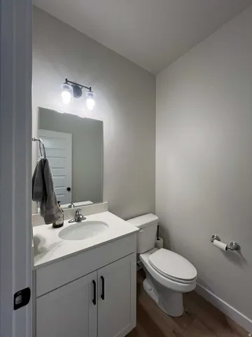 White vanity with a single basin sink, chrome faucet, and black hardware