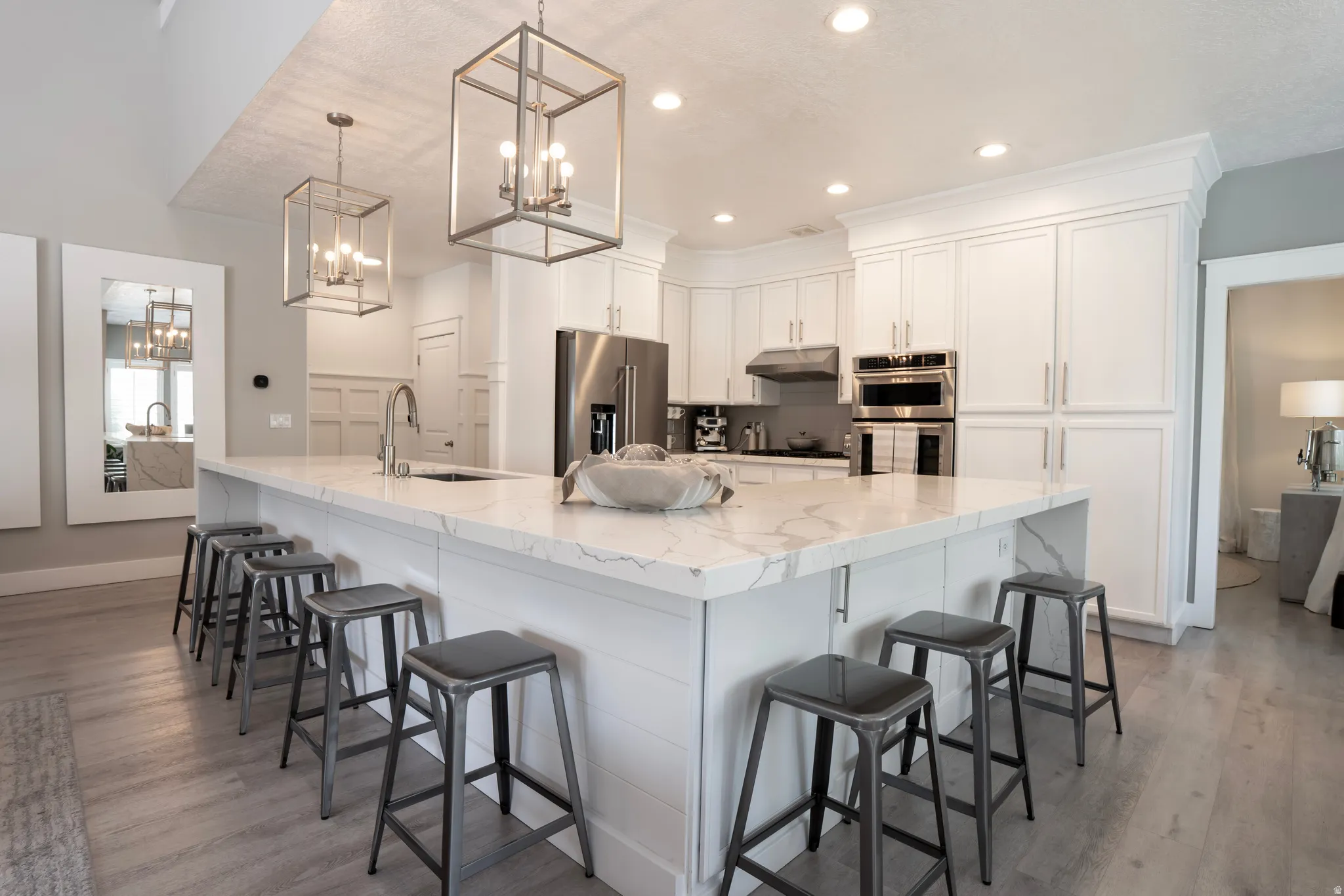 Expansive kitchen island with a stone countertop, featuring an integrated sink and bar seating