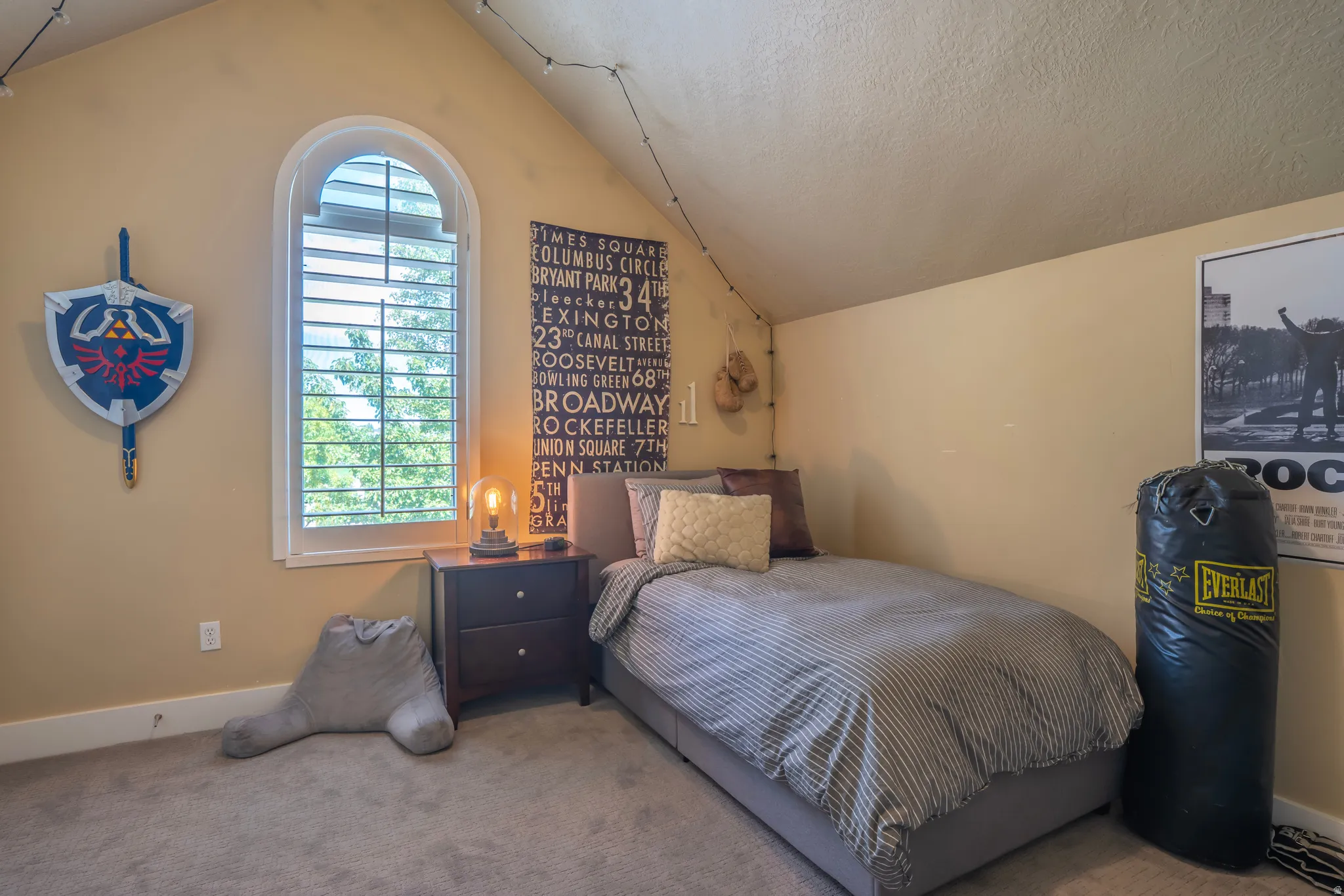 Arched window with louvered shutters, sloped ceiling, and carpeted flooring
