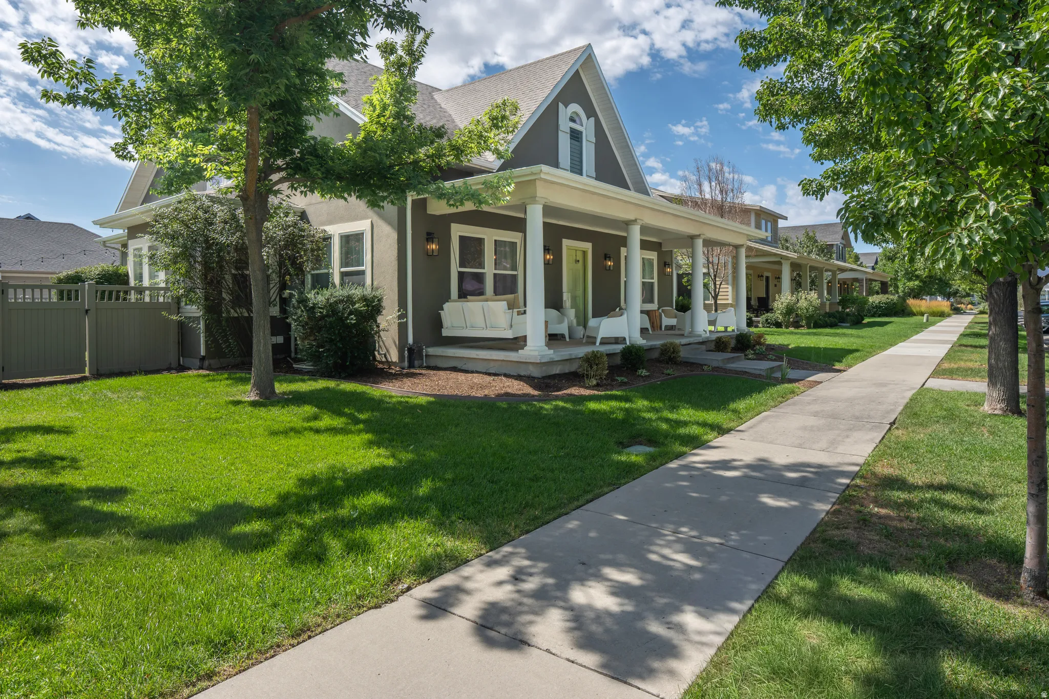 Expansive front porch with column supports, dormer window, and exterior wall sconces