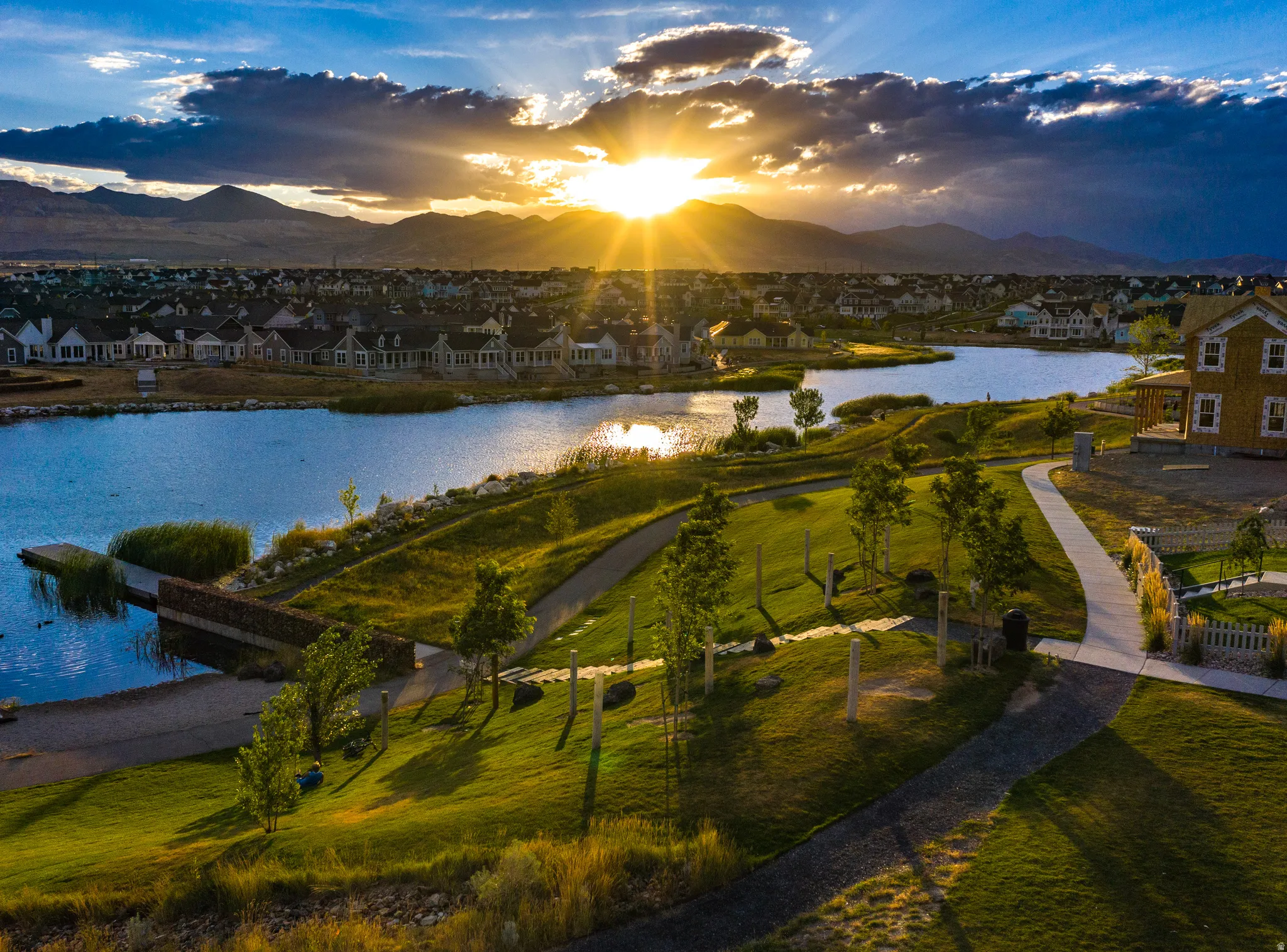 Lakeside community with extensive green spaces, pathways, and mountain scenery