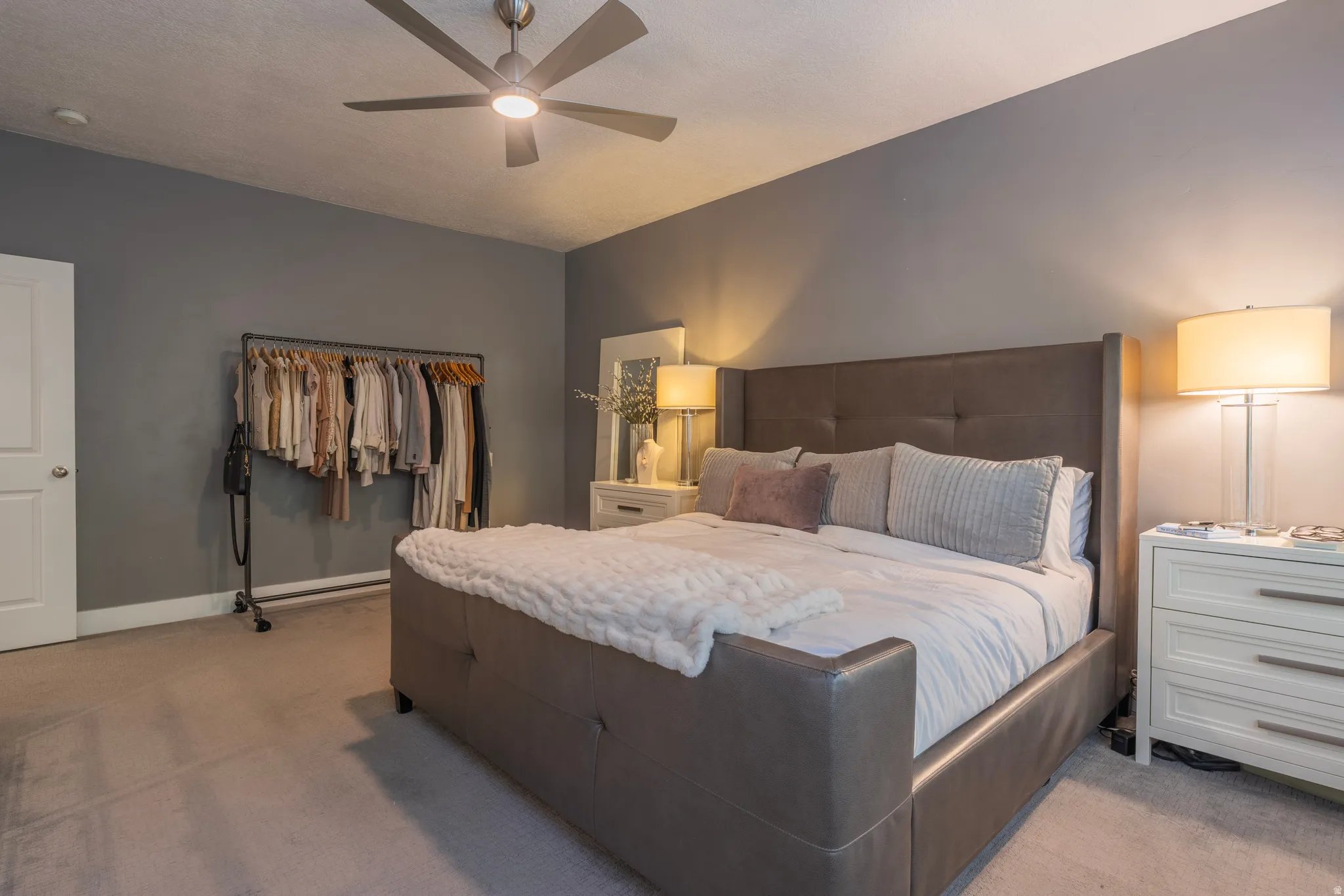 Room featuring a ceiling fan with integrated lighting, gray wall paint, and carpeting