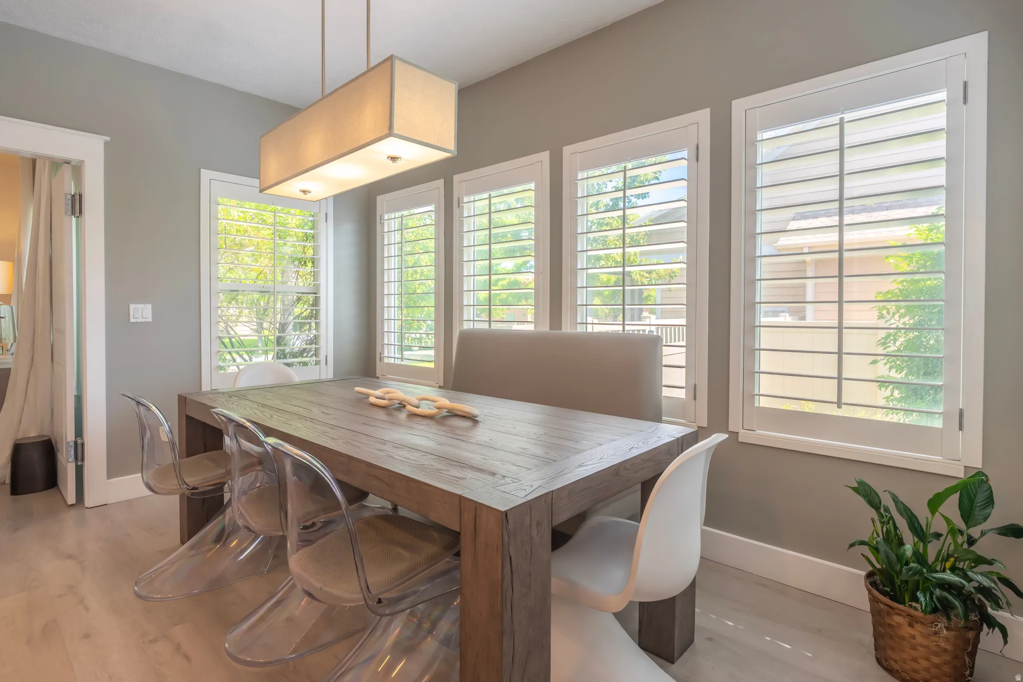 Recessed lighting, wood-finish flooring, multiple windows with plantation shutters, neutral-toned walls, and a rectangular ceiling light fixture