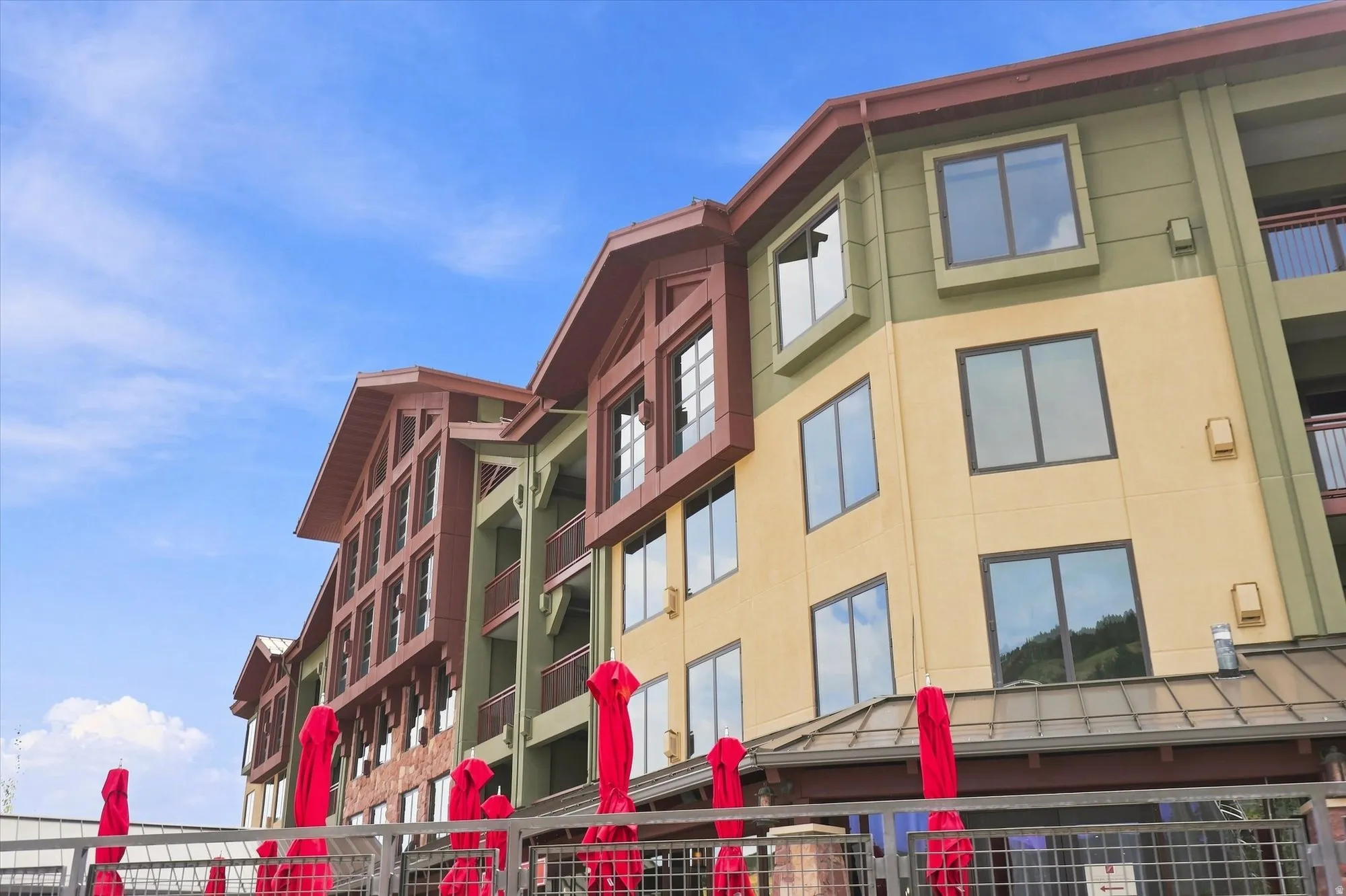 Multi-story building exterior featuring varied siding, multiple window styles, and a gabled roofline