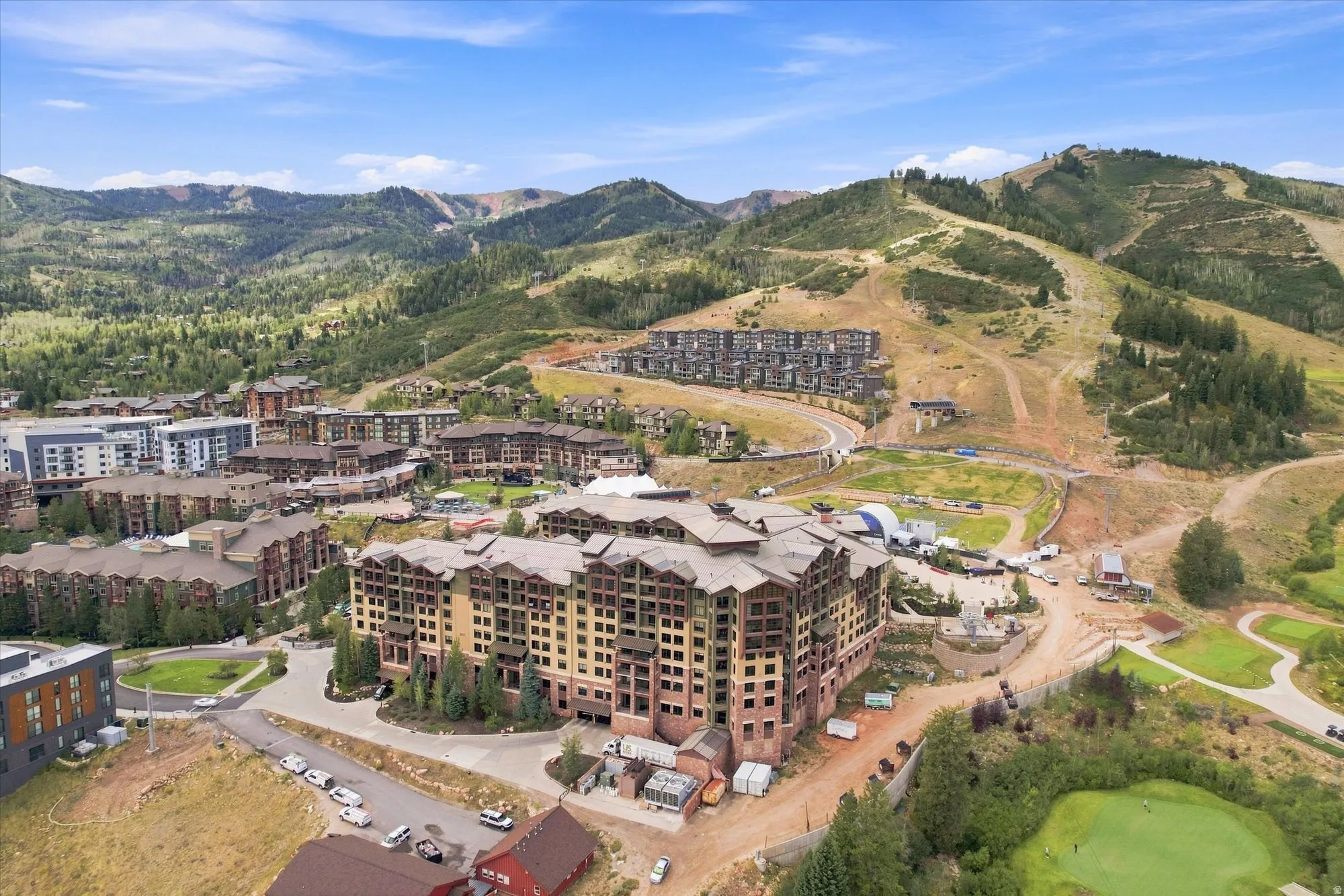 Expansive mountain landscape with multiple residential structures, ski slopes, and a golf course