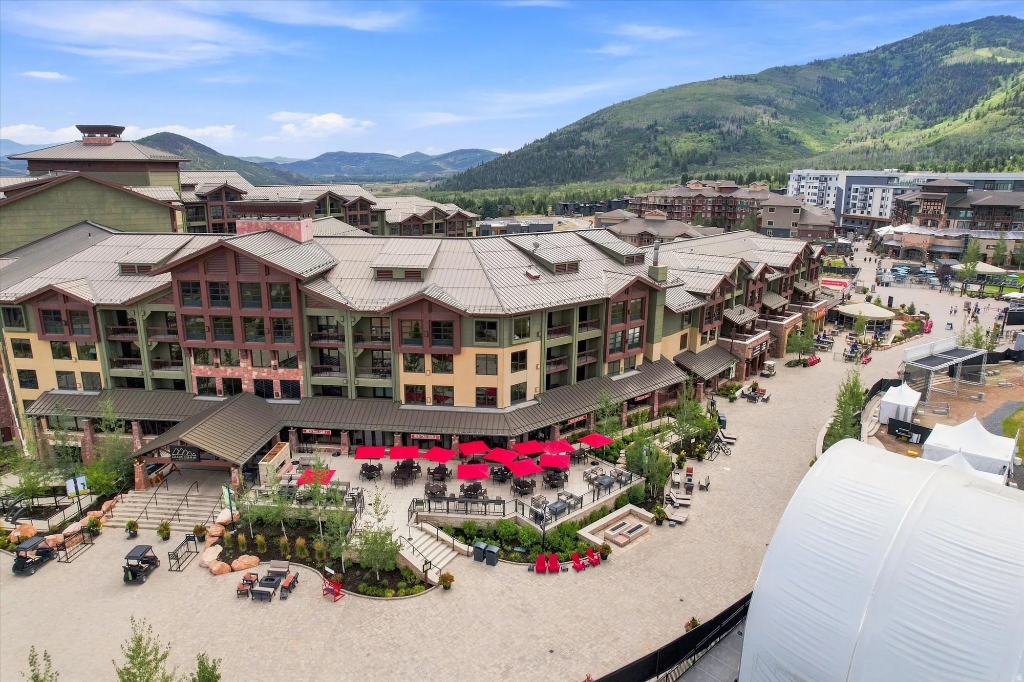 Mountain-inspired architecture with multi-story buildings, extensive exterior dining areas, and varied rooflines