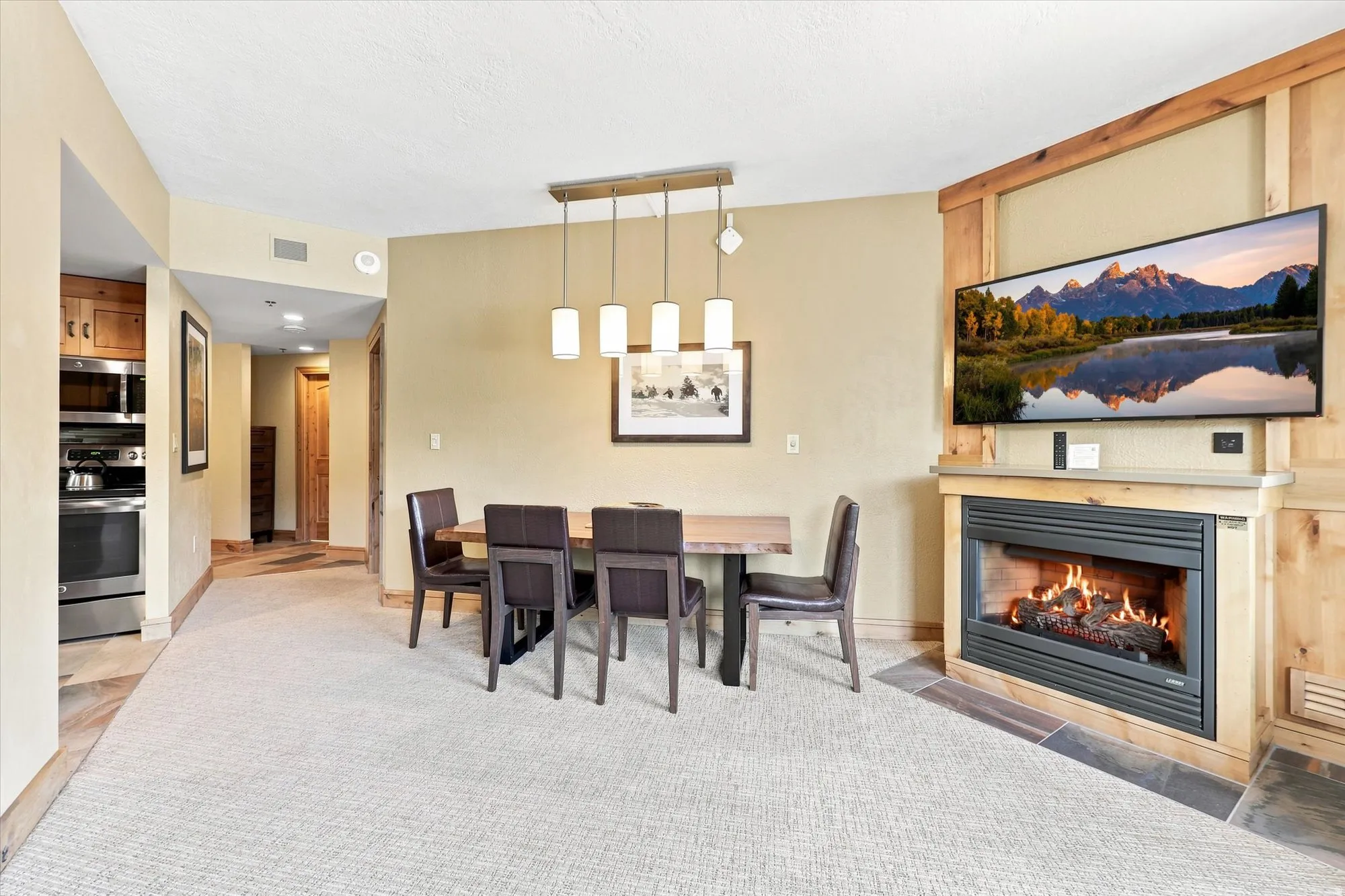 Built-in fireplace with a stone hearth, wood-paneled accent wall, and recessed lighting