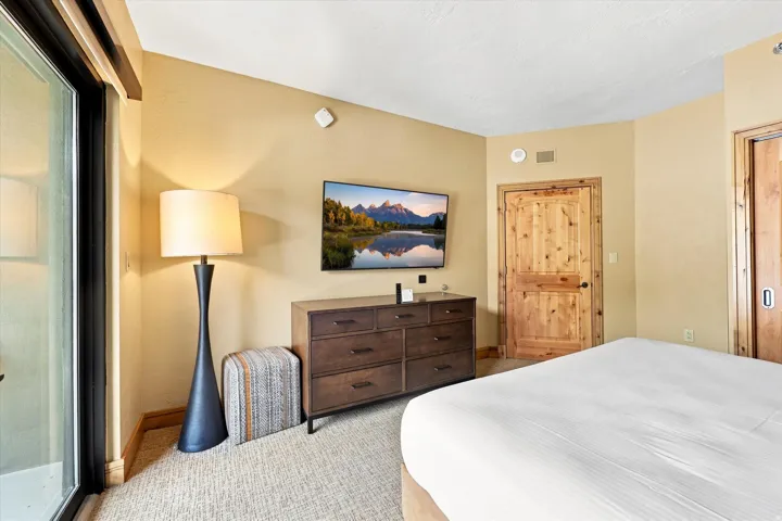 Wall-mounted television above a multi-drawer dresser