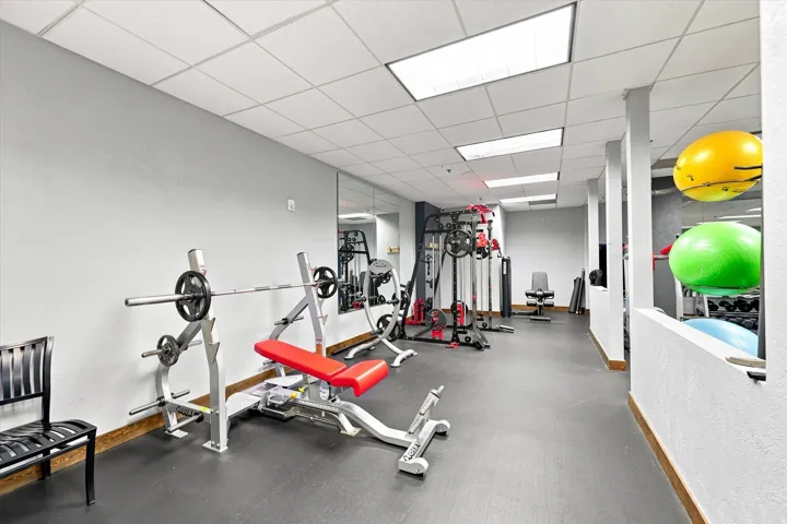 Fitness area featuring resilient flooring and ample overhead lighting