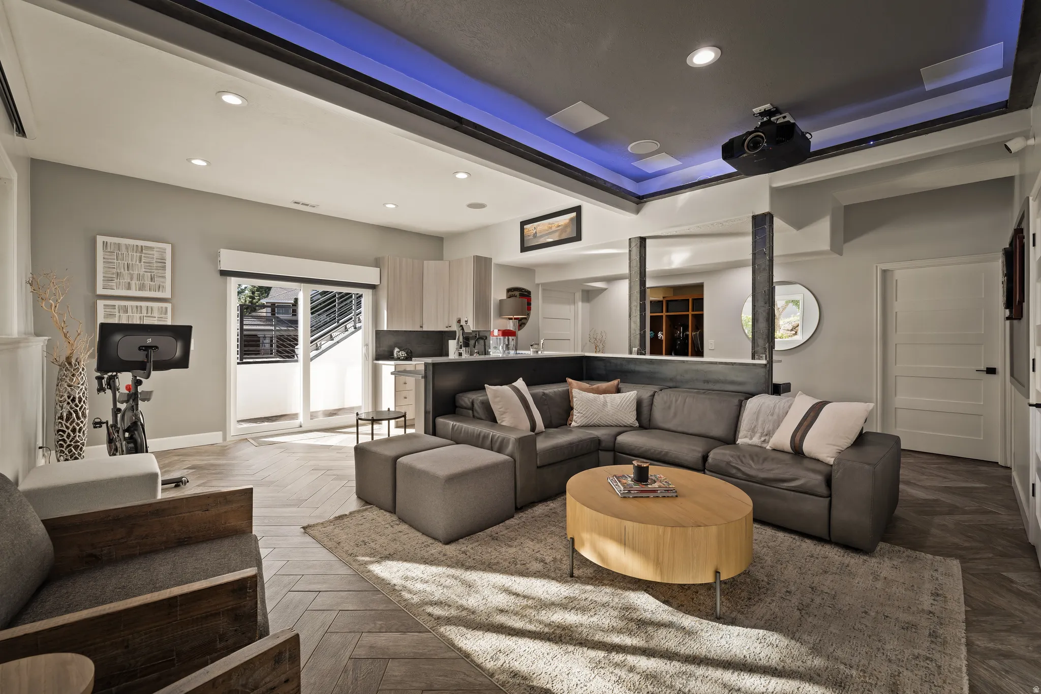 Recessed lighting, wood-finish flooring, sliding glass doors, built-in shelving, and a ceiling-mounted projector