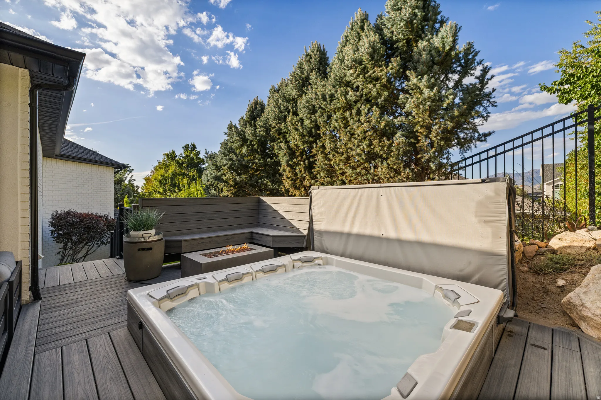 Outdoor deck with a built-in hot tub, composite decking, and integrated bench seating