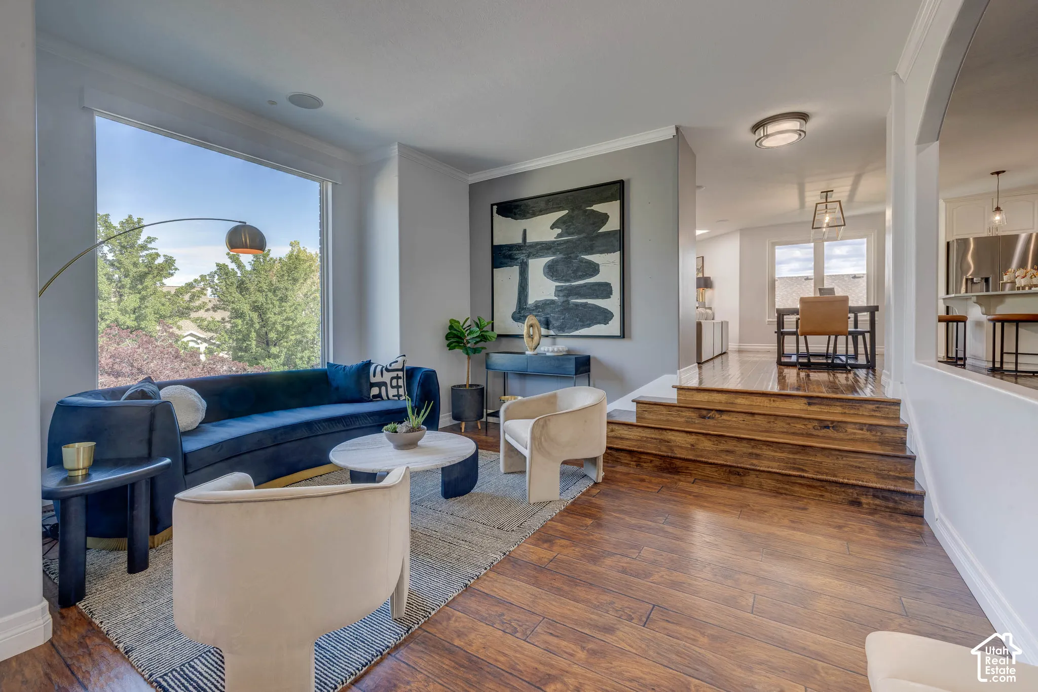 Hardwood flooring, expansive window, built-in ceiling speaker, arched doorway, and recessed lighting