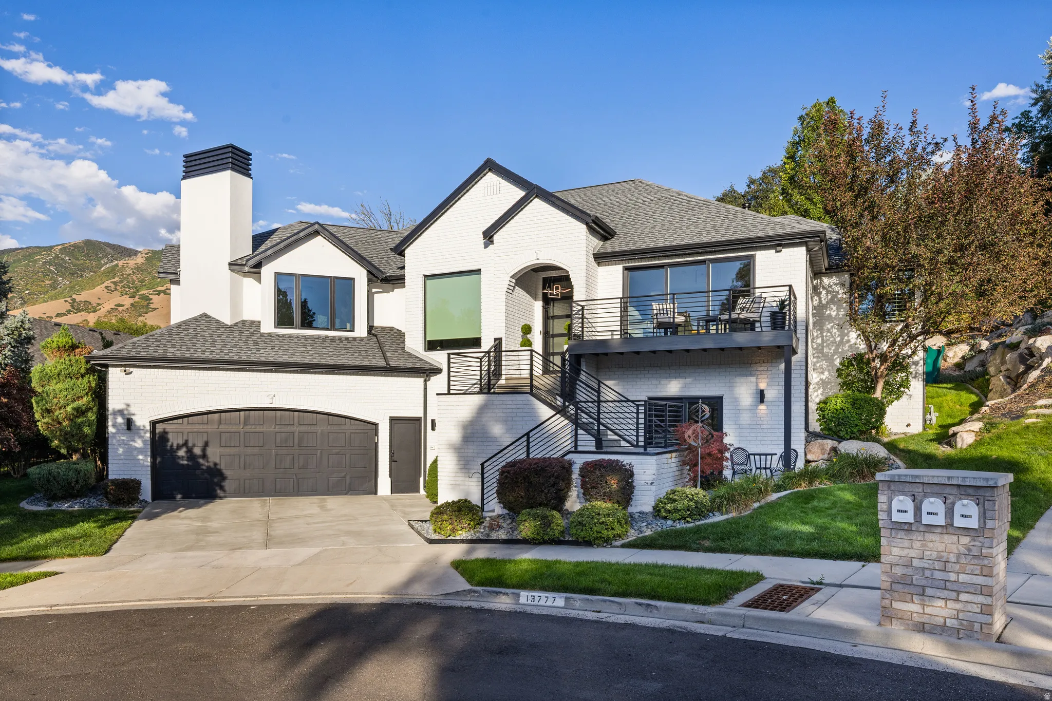 White brick exterior with black trim accents and a black shingled roof