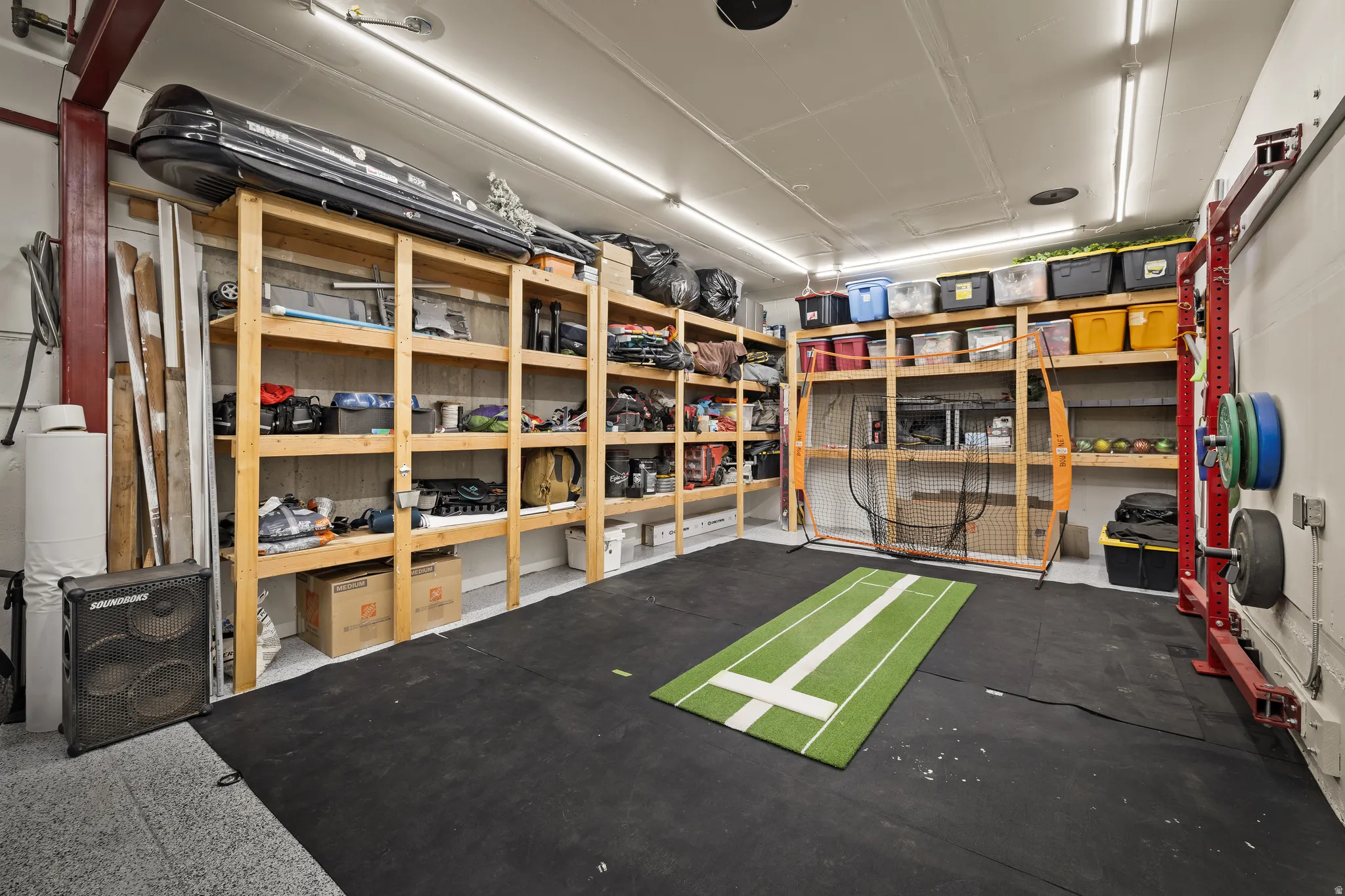 Extensive storage shelving, exposed ceiling joists, and track lighting