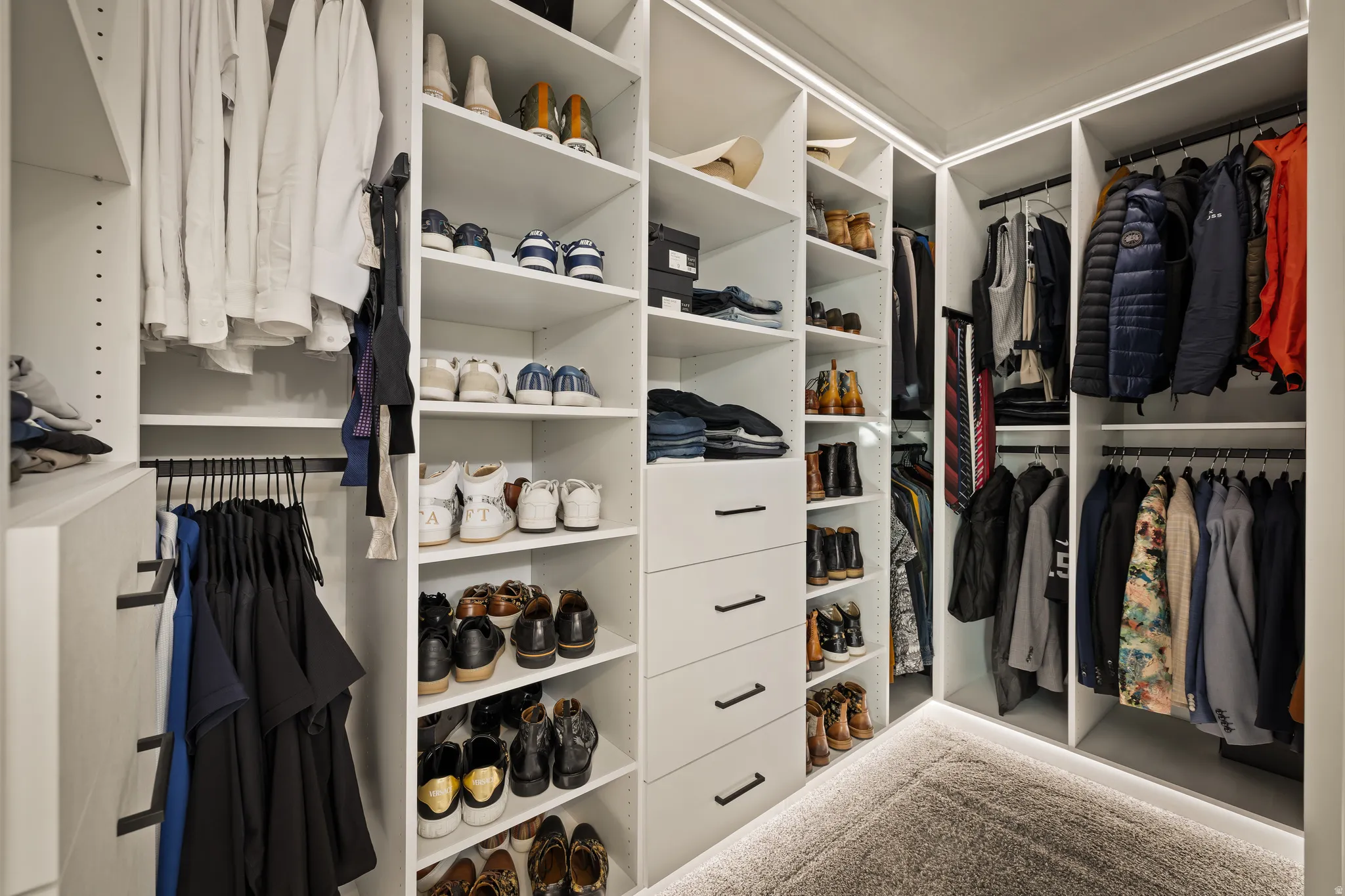 Built-in closet system with multiple shelving units, hanging rods, and integrated drawers