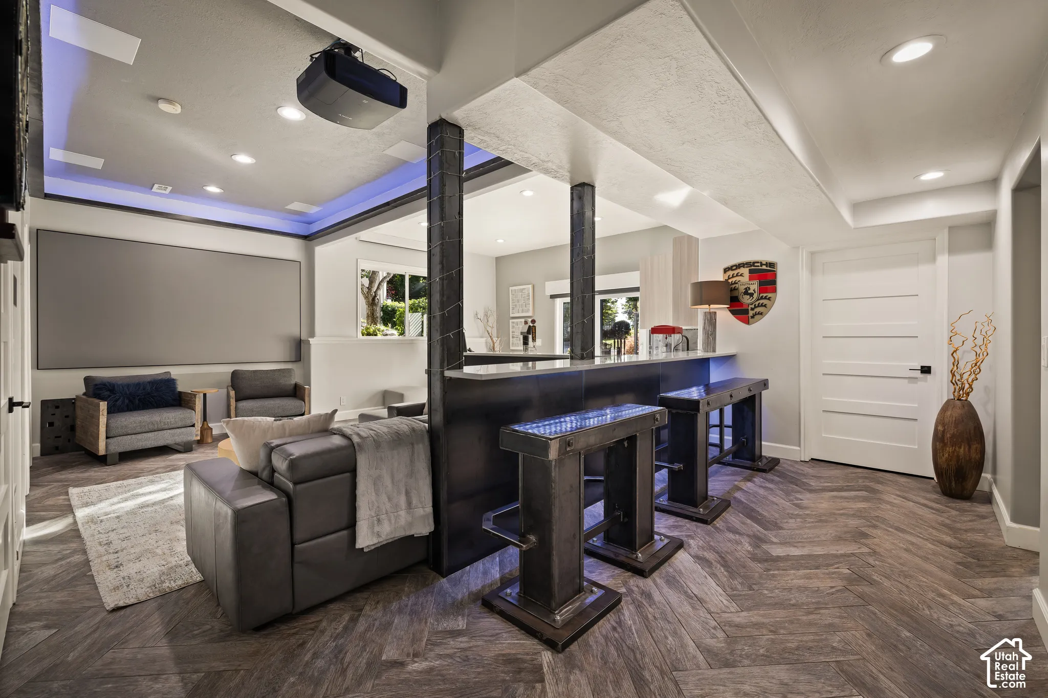 Home theater with a built-in screen, a projector, recessed lighting, and a wet bar