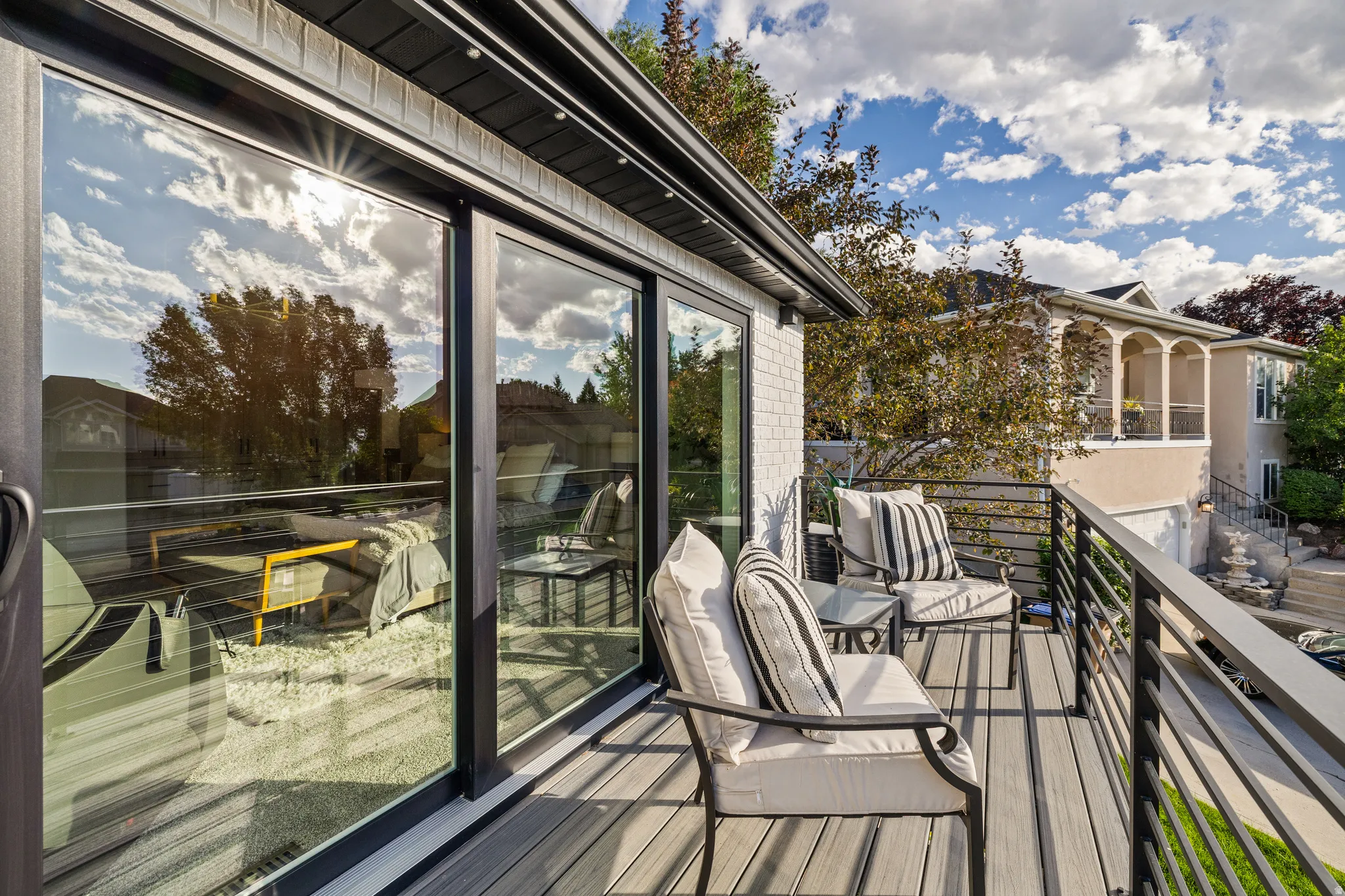 Expansive outdoor deck featuring composite decking, black metal railings, and large sliding glass doors