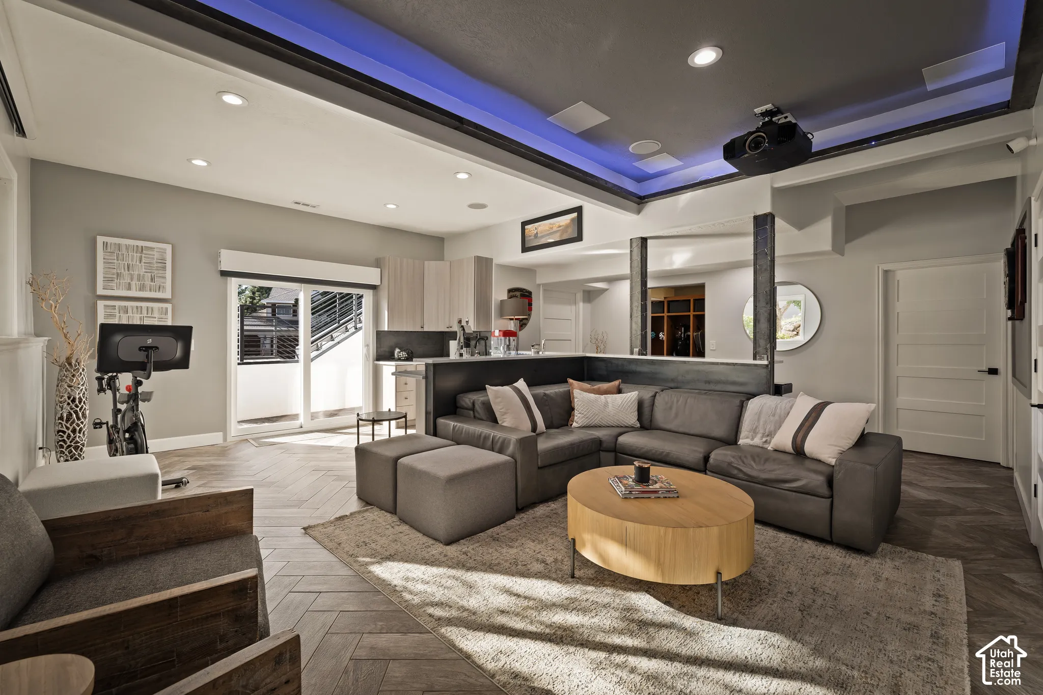 Recessed lighting, wood-finish flooring, sliding glass doors, built-in shelving, and a ceiling-mounted projector