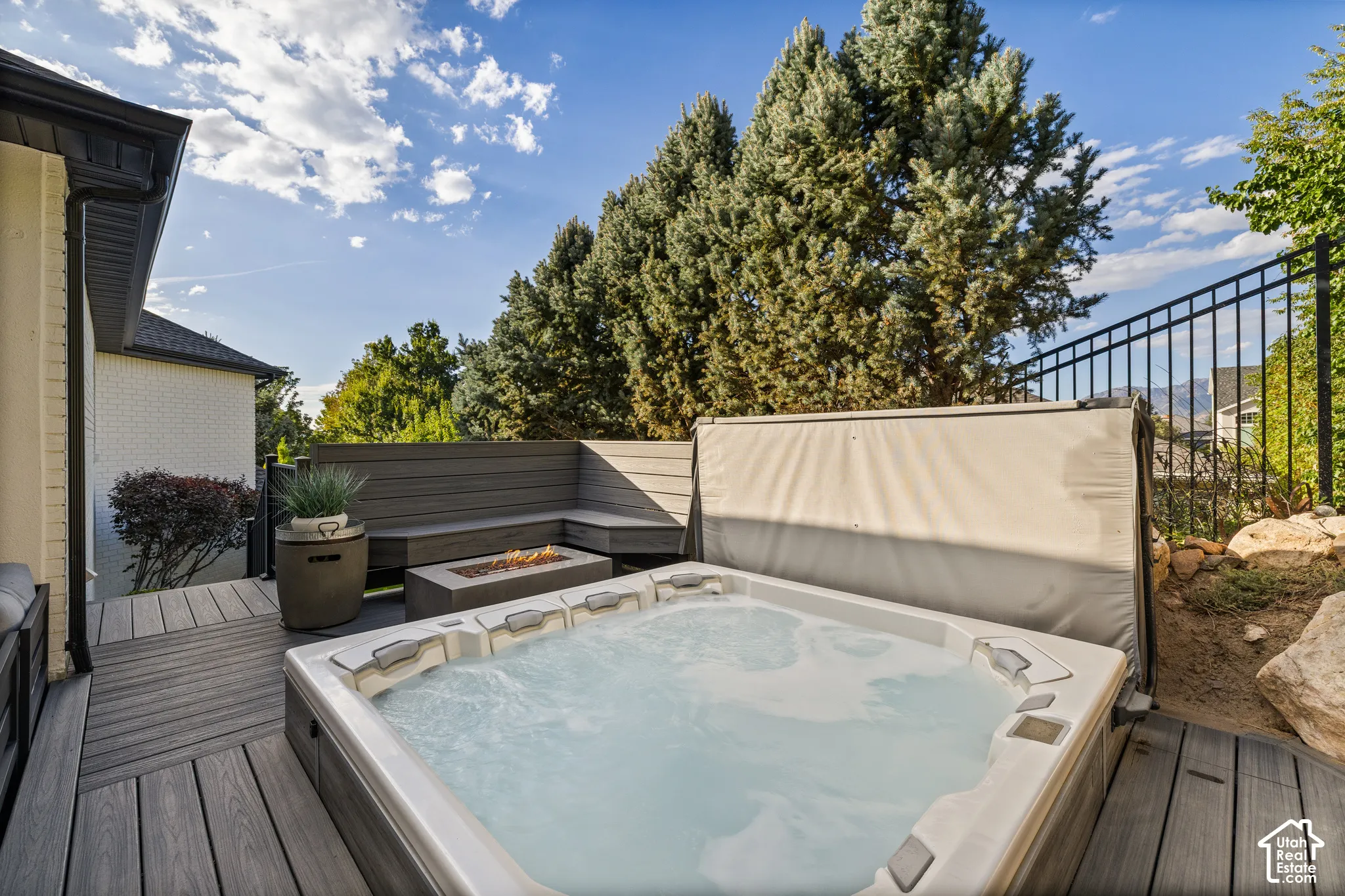 Outdoor deck with a built-in hot tub, composite decking, and integrated bench seating