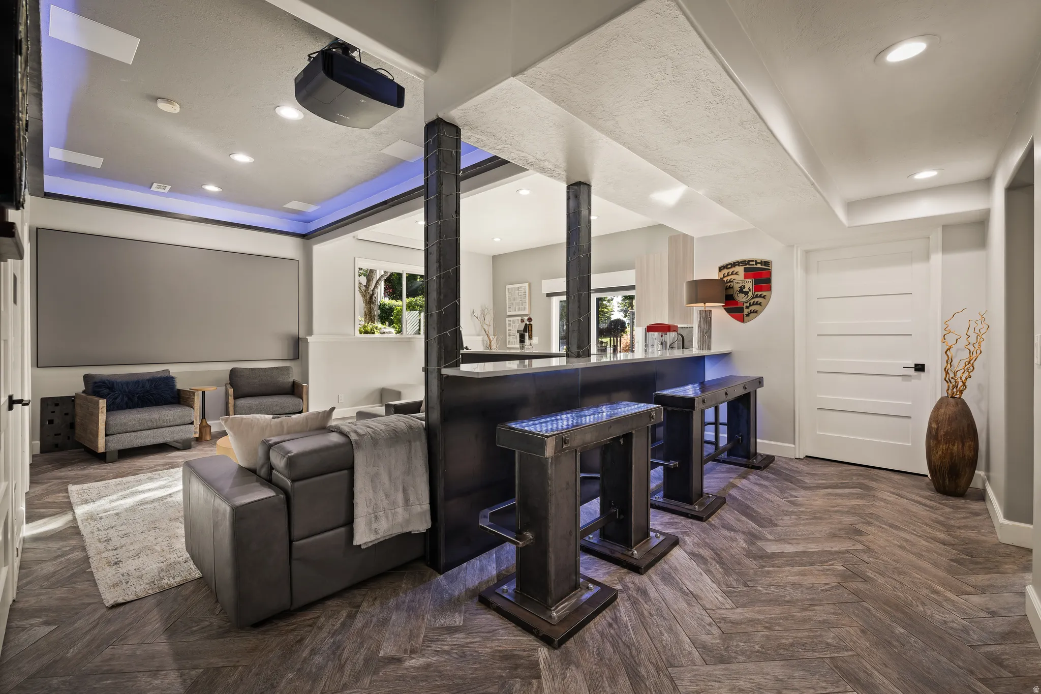 Home theater with a built-in screen, a projector, recessed lighting, and a wet bar