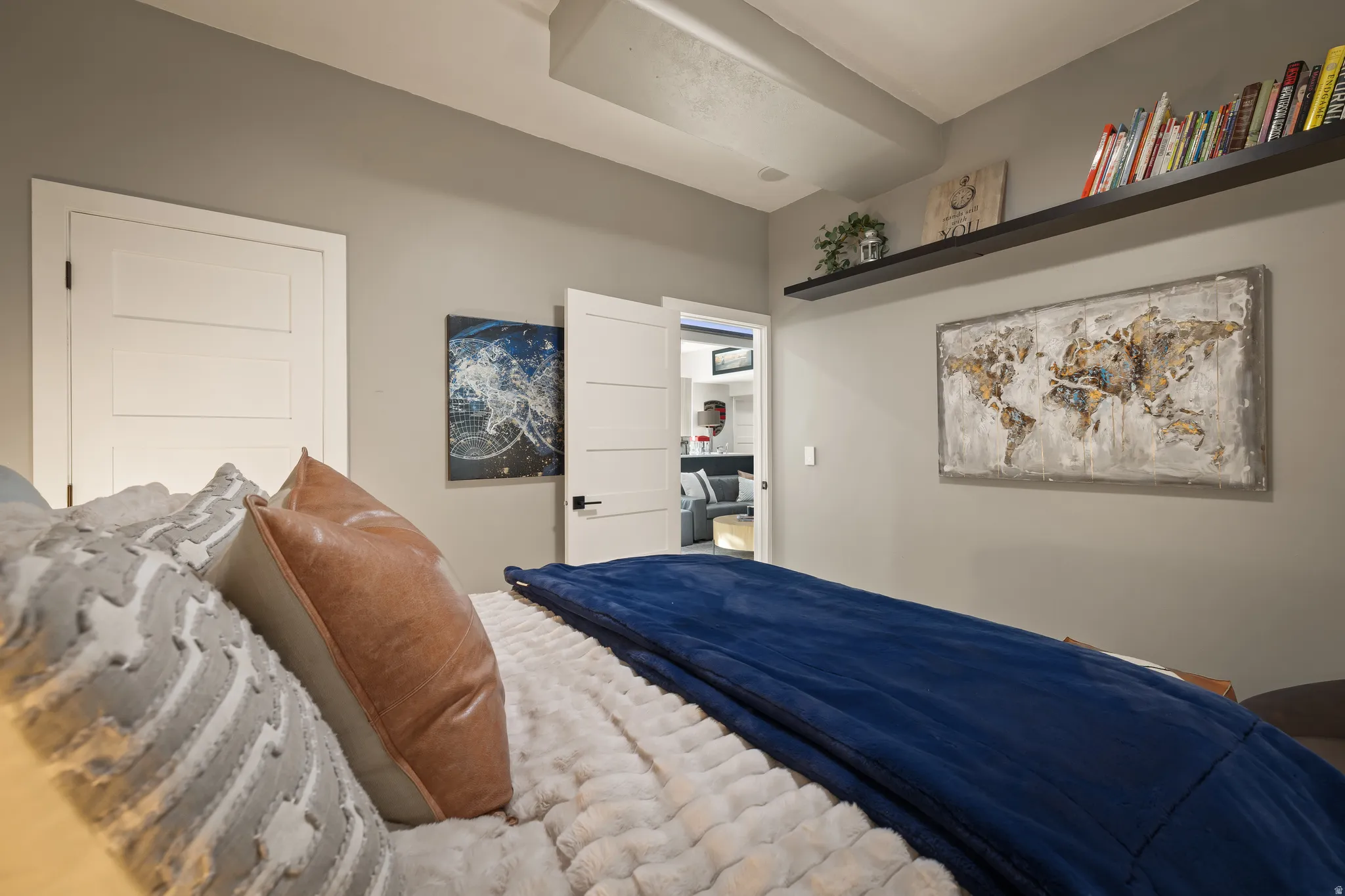 Recessed ceiling beam with flush-mounted lighting, white solid core doors, and a built-in wall shelf